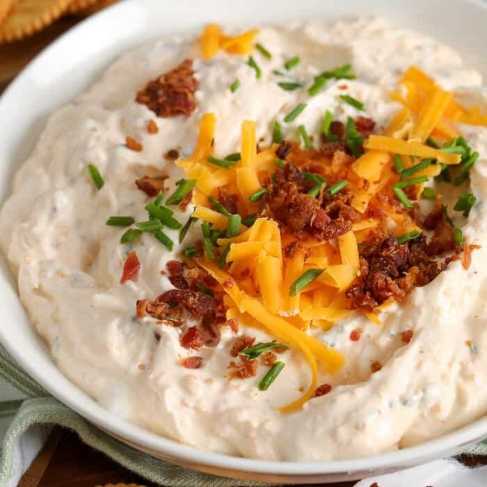 Crack dip in a bowl with cheese bacon and chives
