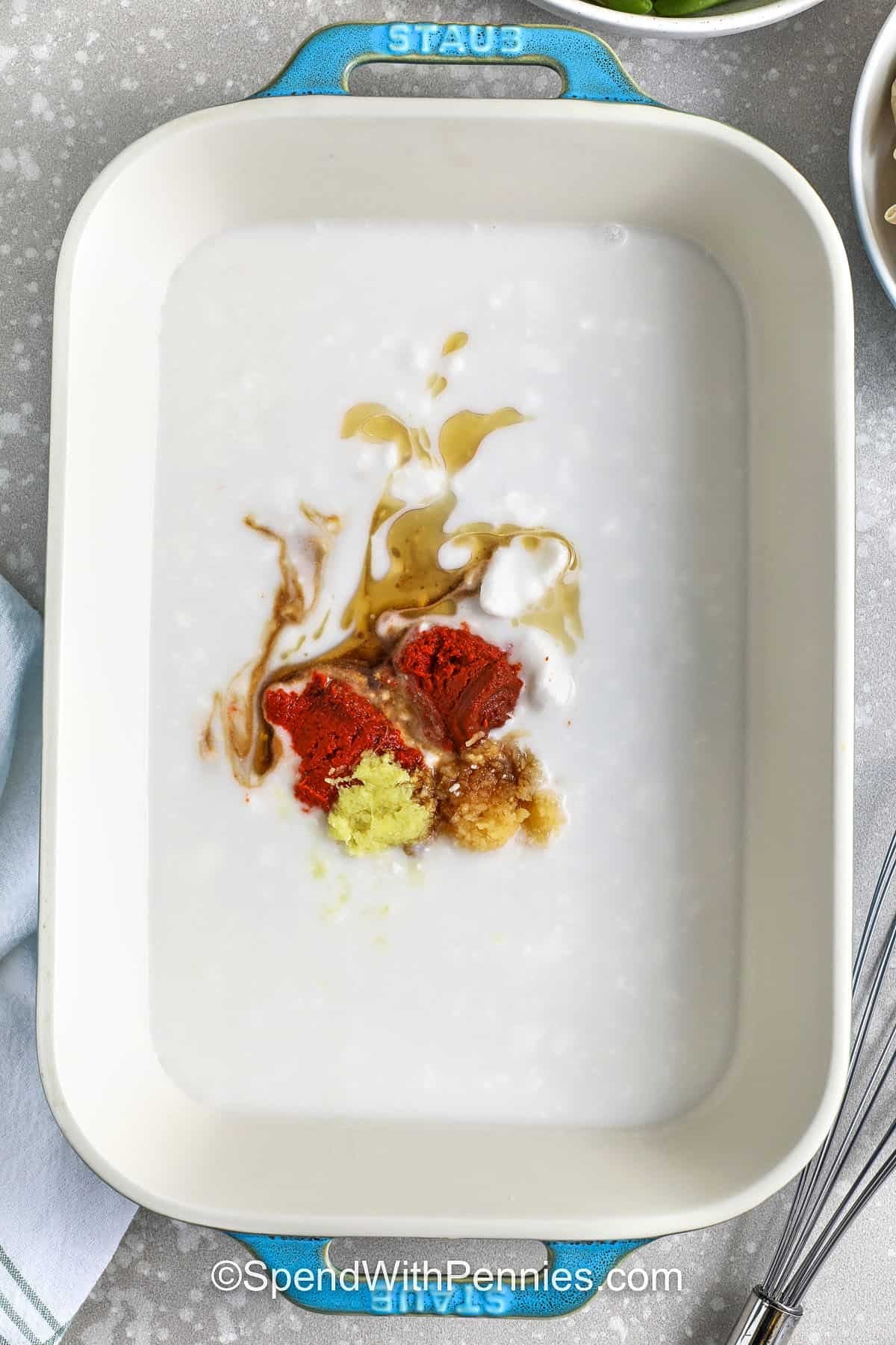 adding ingredients to coconut milk in casserole dish to make Dumpling Bake