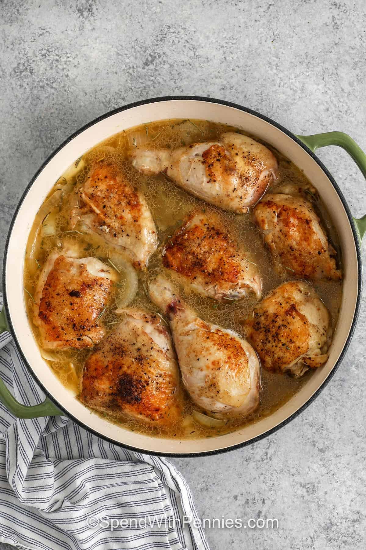 adding chicken to broth and onions in pot to make Easy Braised Chicken
