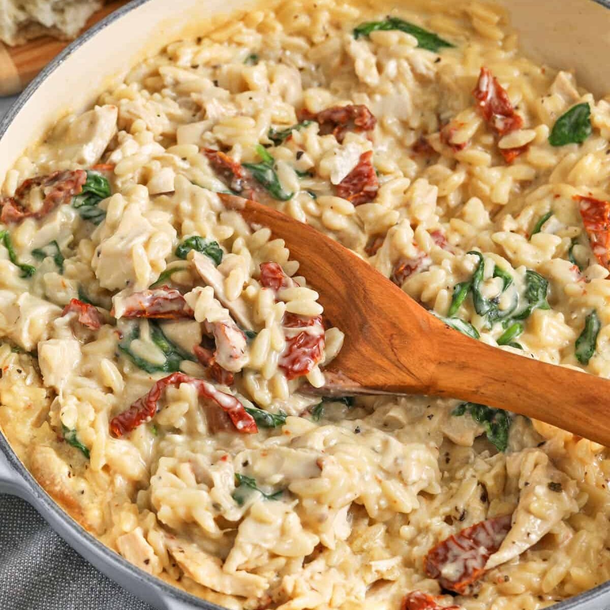 Marry Me Chicken Orzo in the pot with a wooden spoon