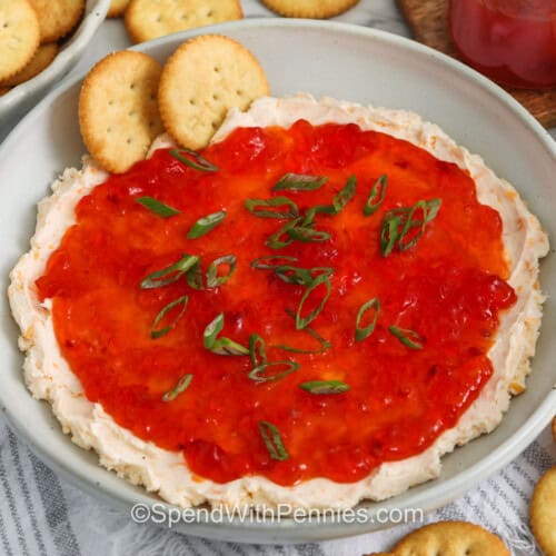 pepper jelly cheese dip with crackers in a gray bowl