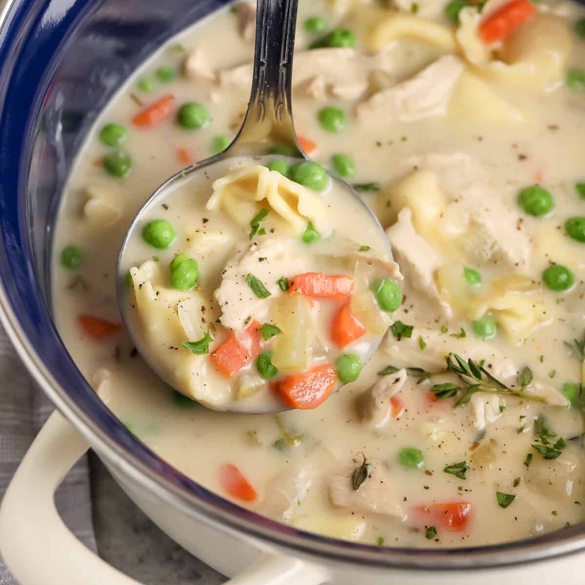 pot of Creamy Chicken Tortellini Soup with a spoon full