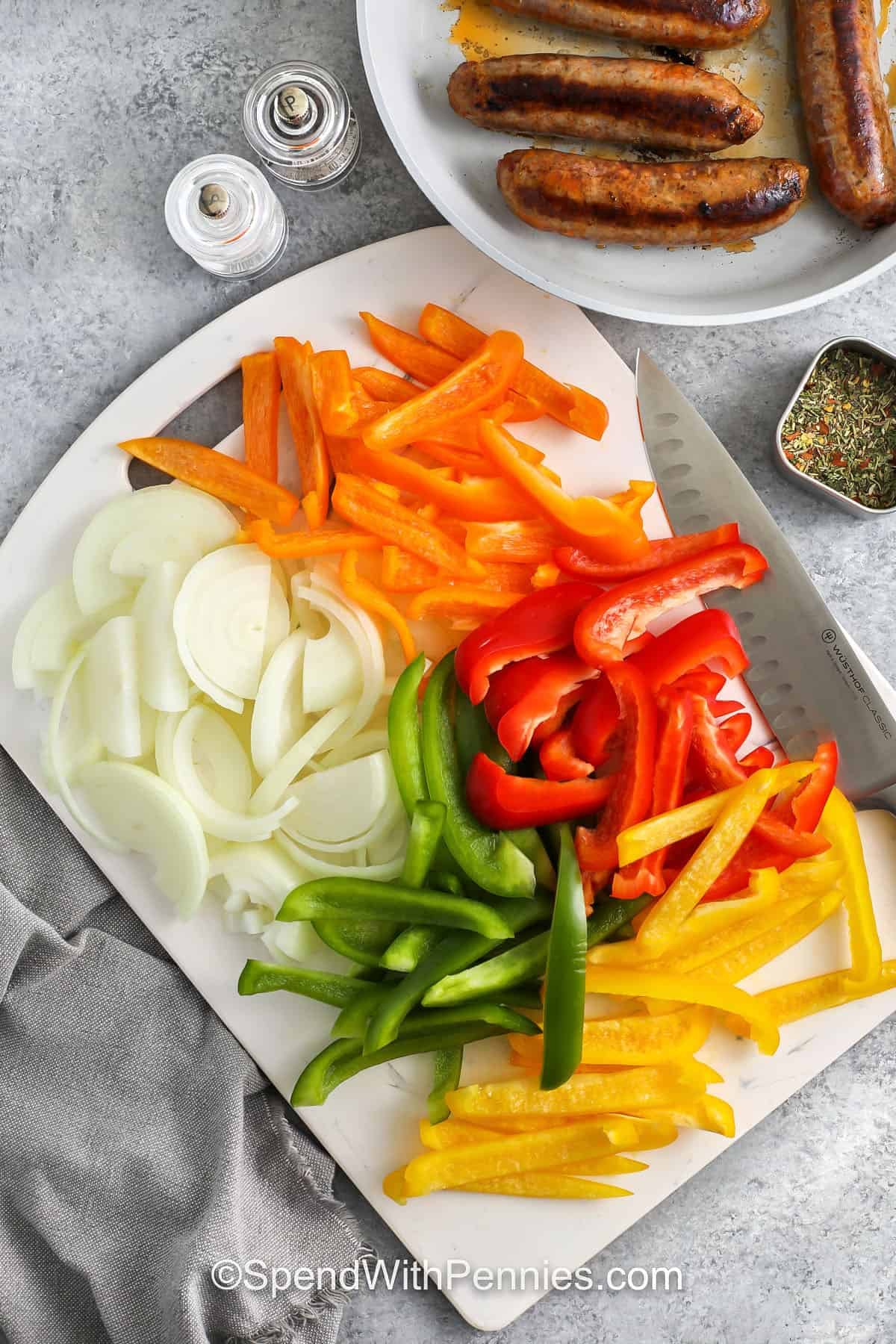 slicing bell peppers and onion to make Slow Cooker Sausage and Peppers