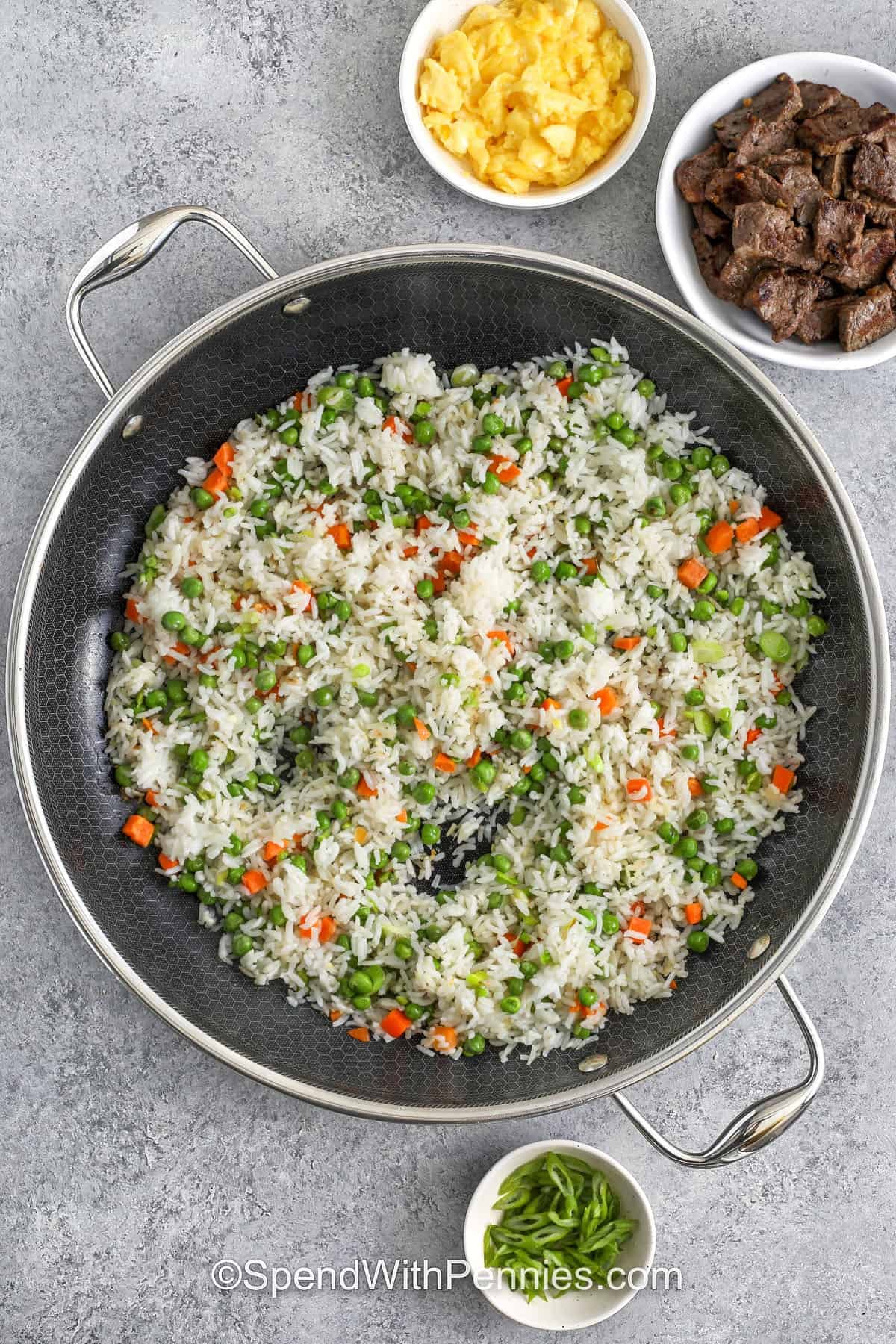 adding rice to cooked veggies to make Steak Fried Rice