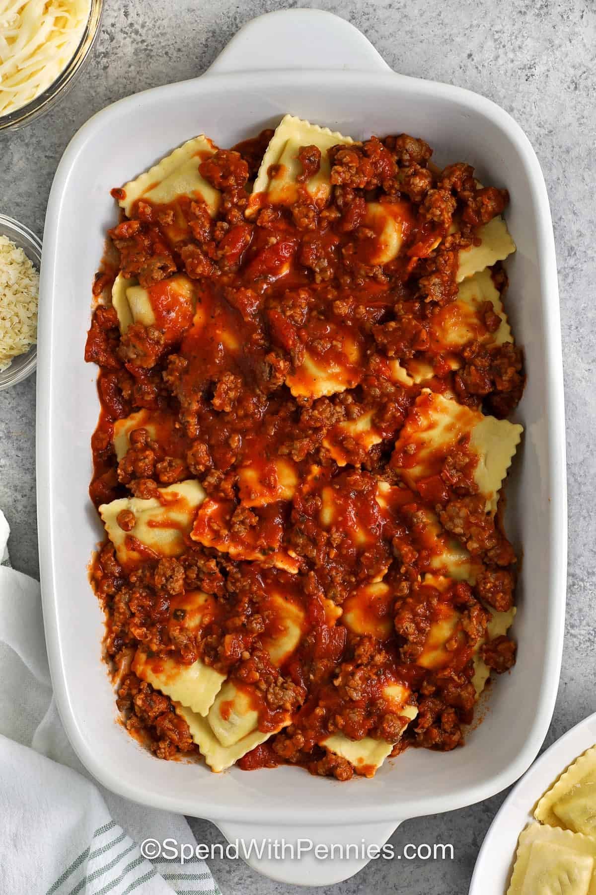 adding meat sauce to ravioli to make Ravioli Lasagna