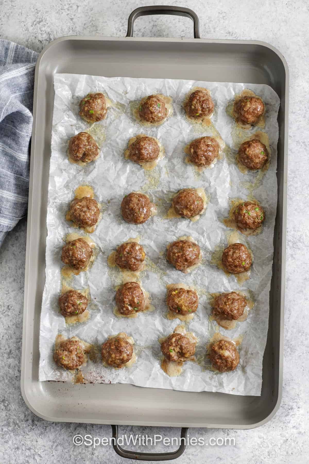These firecracker meatballs come together with simple pantry seasonings and a quick oven bake, so dinner stays easy without losing flavor. The firecracker sauce mixes mayonnaise, sriracha, honey, soy sauce, and a touch of toasted sesame oil for a bold, creamy bite. Garnish with sesame seeds and green onions, then serve as rice bowls or party meatballs. #spendwithpennies firecracker meatballs on a pan