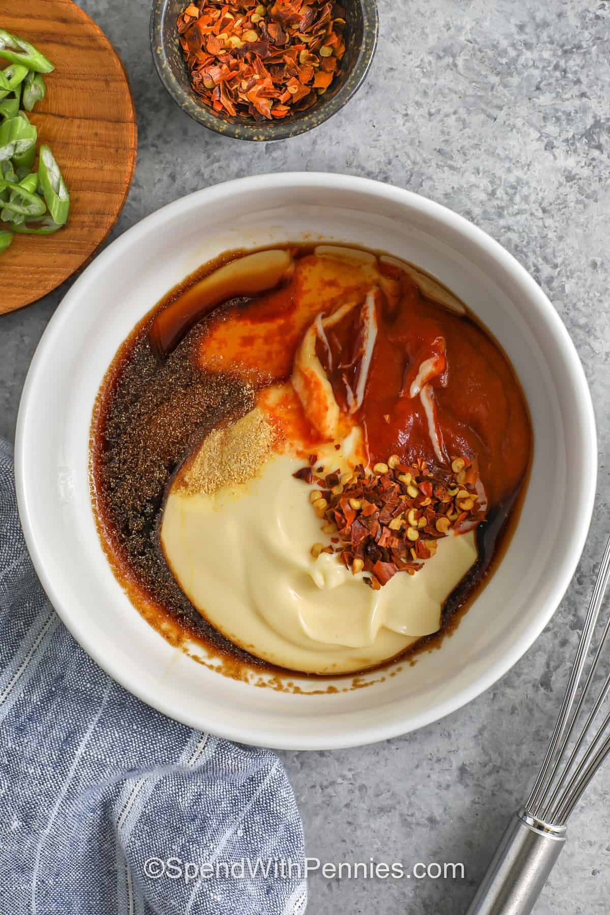 Firecracker meatballs are a weeknight-friendly recipe that tastes like a restaurant appetizer at home. Bake the meatballs until juicy, then finish with a spicy sweet firecracker sauce made from sriracha and mayo with soy and honey. Adjust the heat to your taste and add red pepper flakes if you like it hotter. Firecracker Meatballs are great for meal prep with rice and veggies. #spendwithpennies firecracker meatball sauce in a bowl