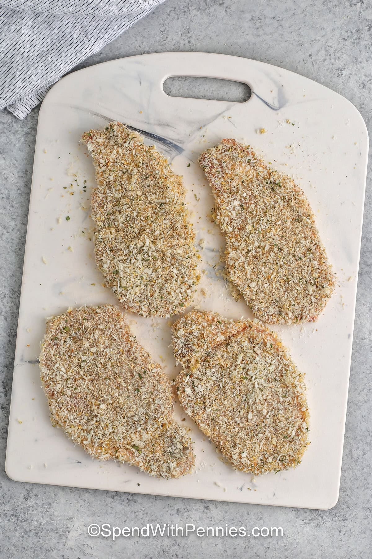 breaded Pork Cutlets on a cutting board before cooking