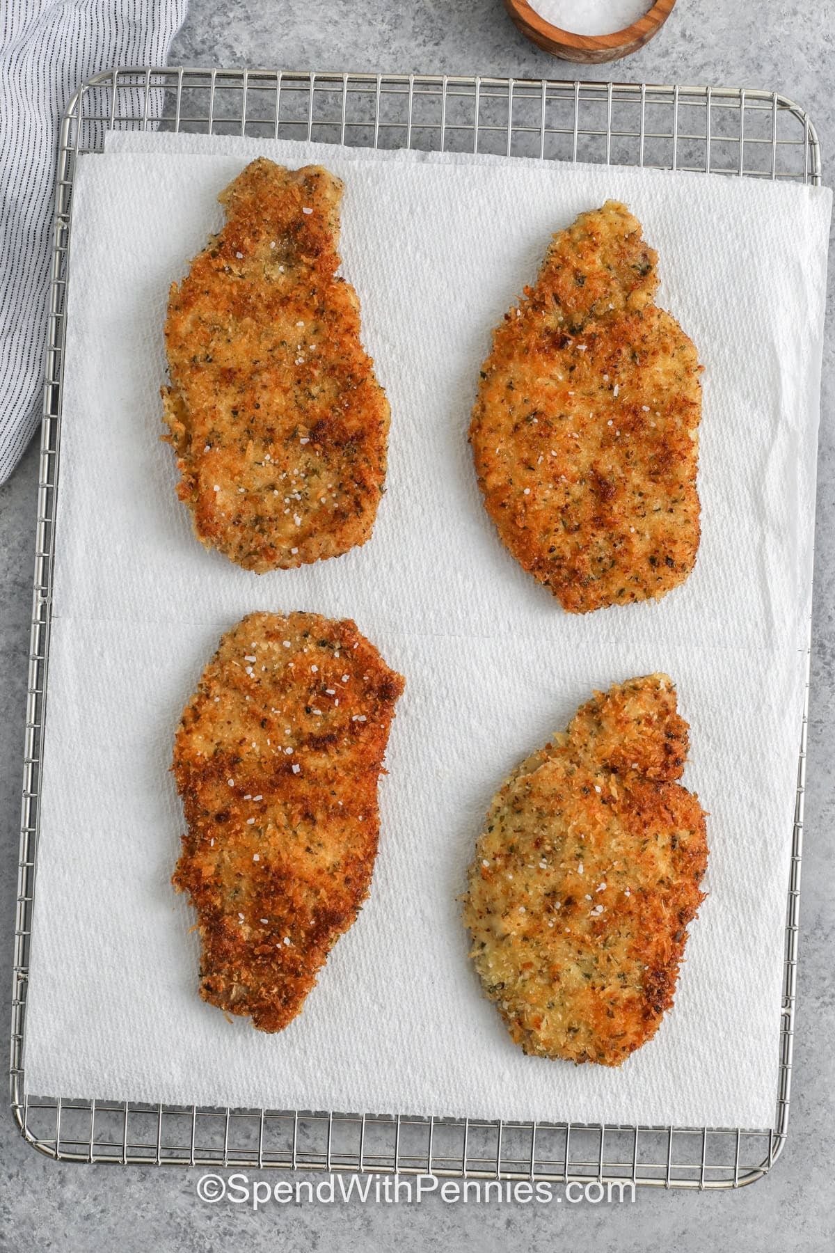 baked Pork Cutlets on a paper towel and metal rack