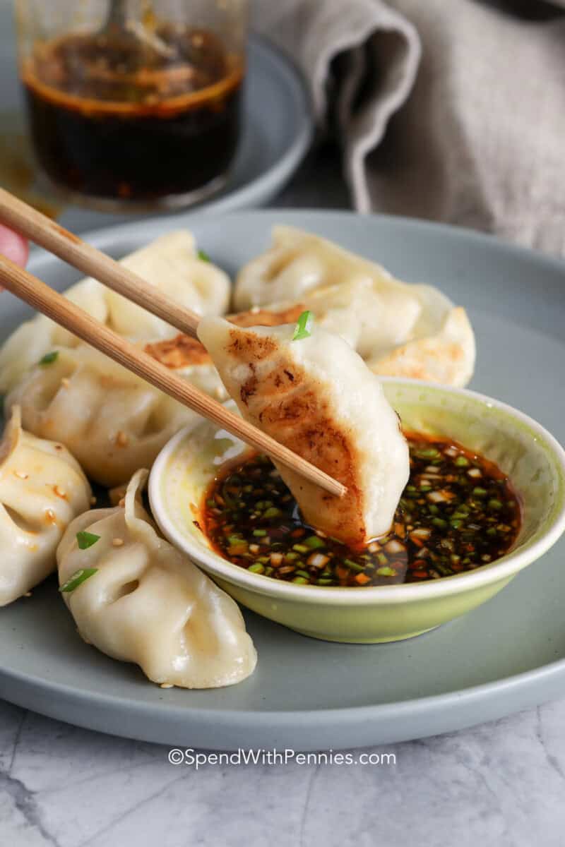 A dumpling being dipped in dumpling sauce