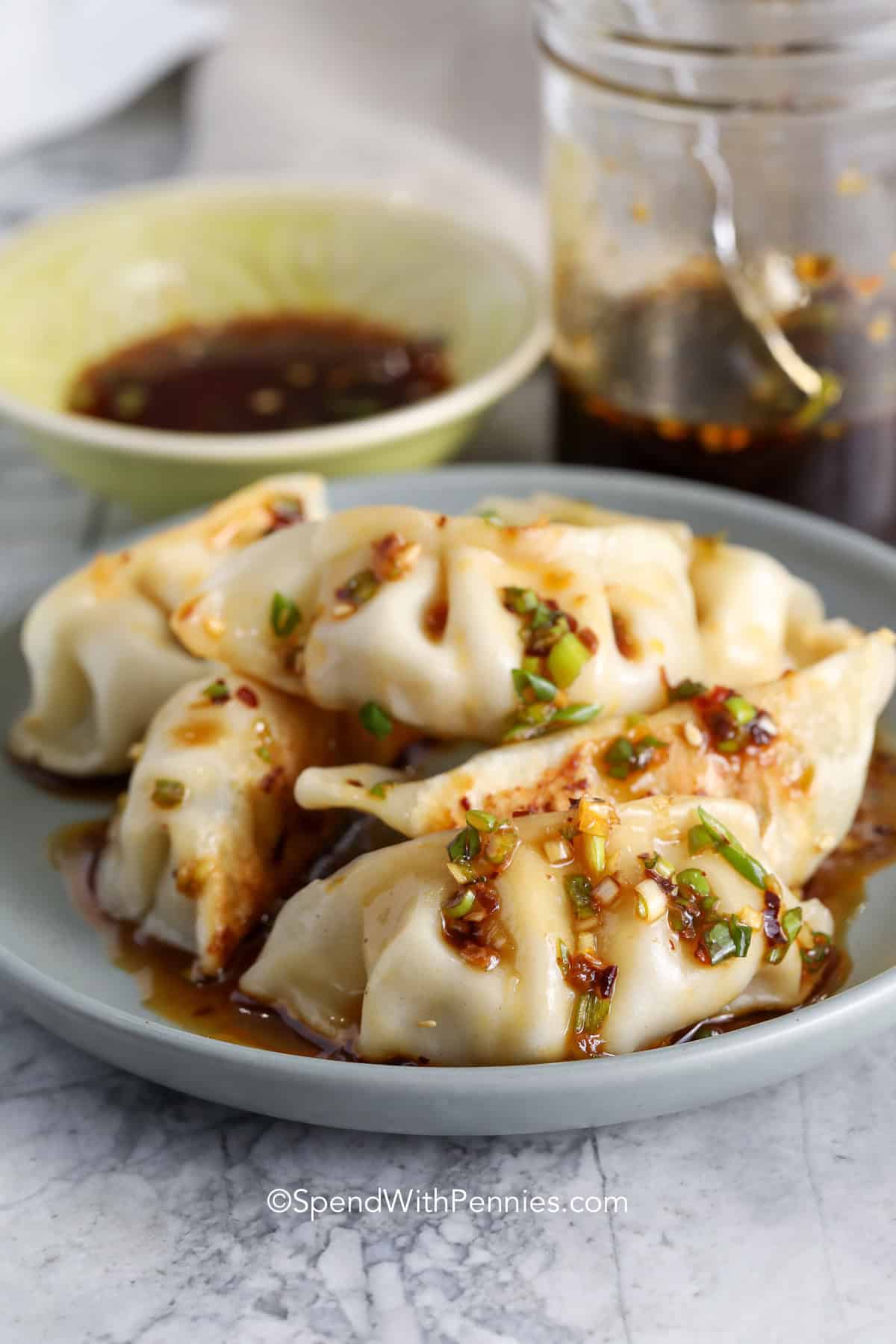 A great dumpling sauce does not need a long ingredient list, and this recipe proves it. With soy sauce, rice vinegar, sesame oil, green onion, and a little sweetener, it has the salty, tangy, nutty flavor that makes dumplings even more satisfying. It is especially helpful for quick dinners because it is ready in 5 minutes and turns frozen dumplings, potstickers, or noodles into something that feels homemade. #spendwithpennies A plate of dumplings drizzled with dumpling sauce