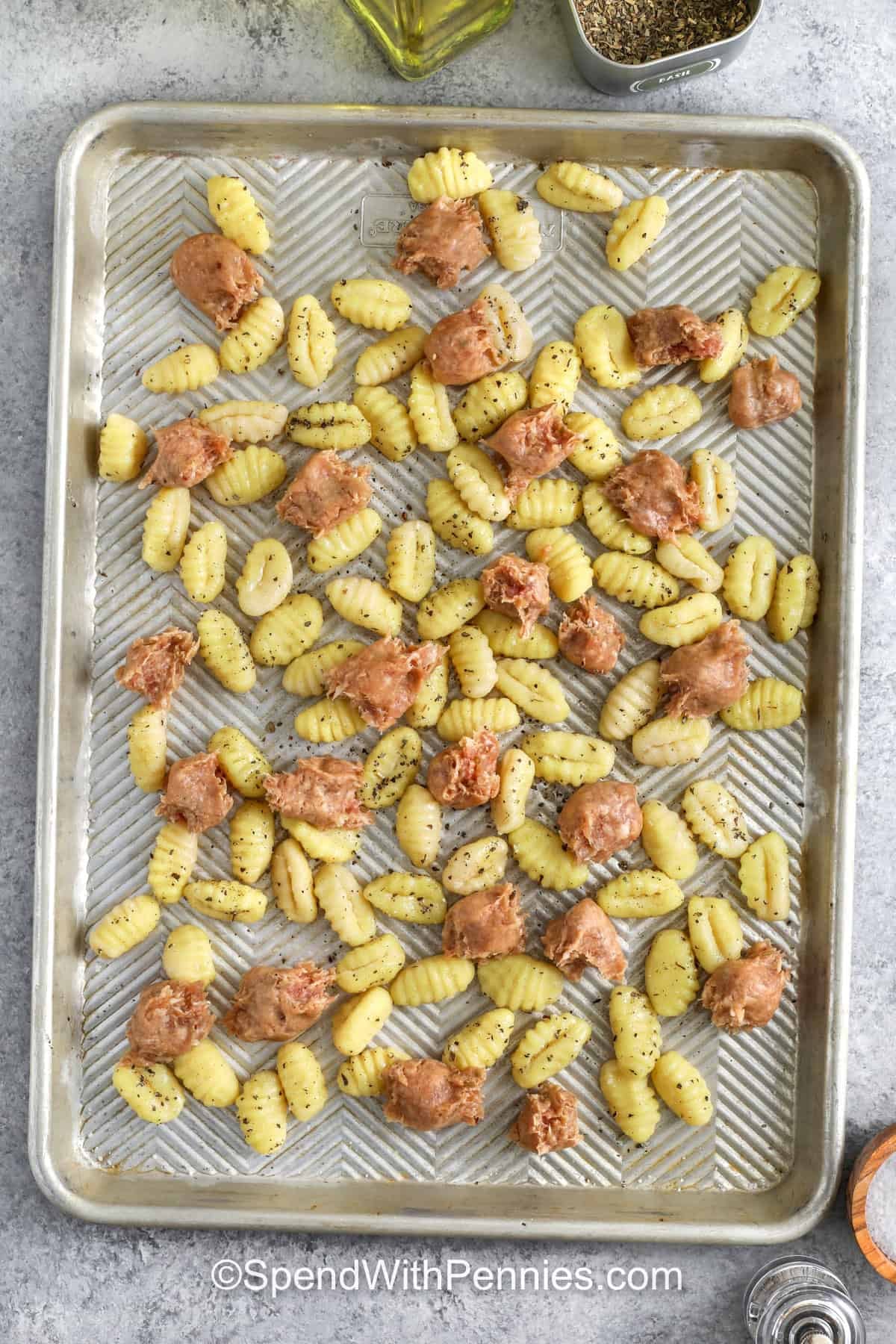adding sausage to gnocchi on sheet pan to make Sheet Pan Gnocchi & Sausage