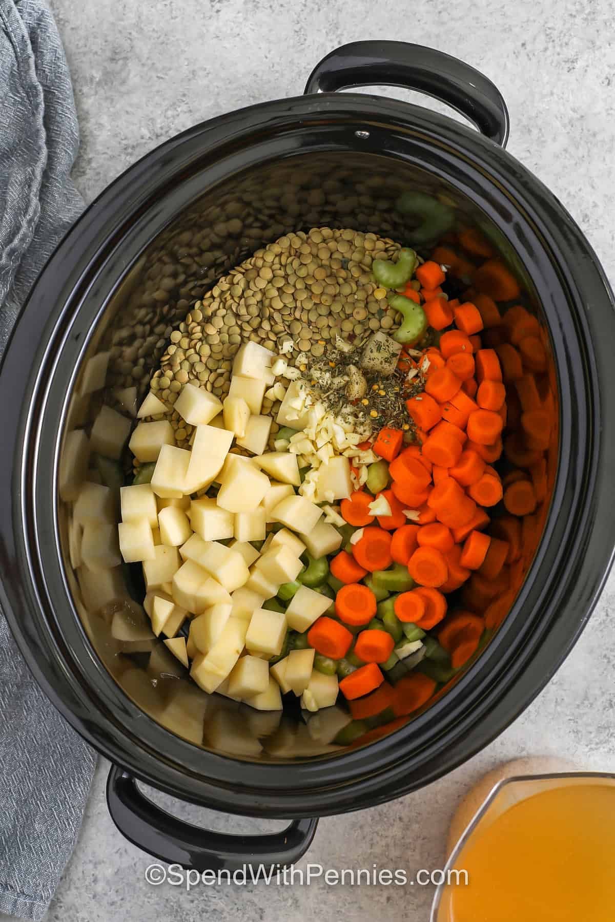 adding potatoes , lentils and vegetables to make Slow Cooker Lentil Soup