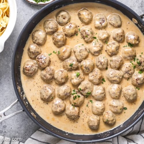 Cooked Swedish meatballs with parsley next to egg noodles