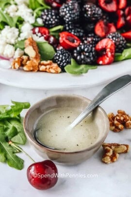bowl of Easy Arugula Salad Dressing with plated salad