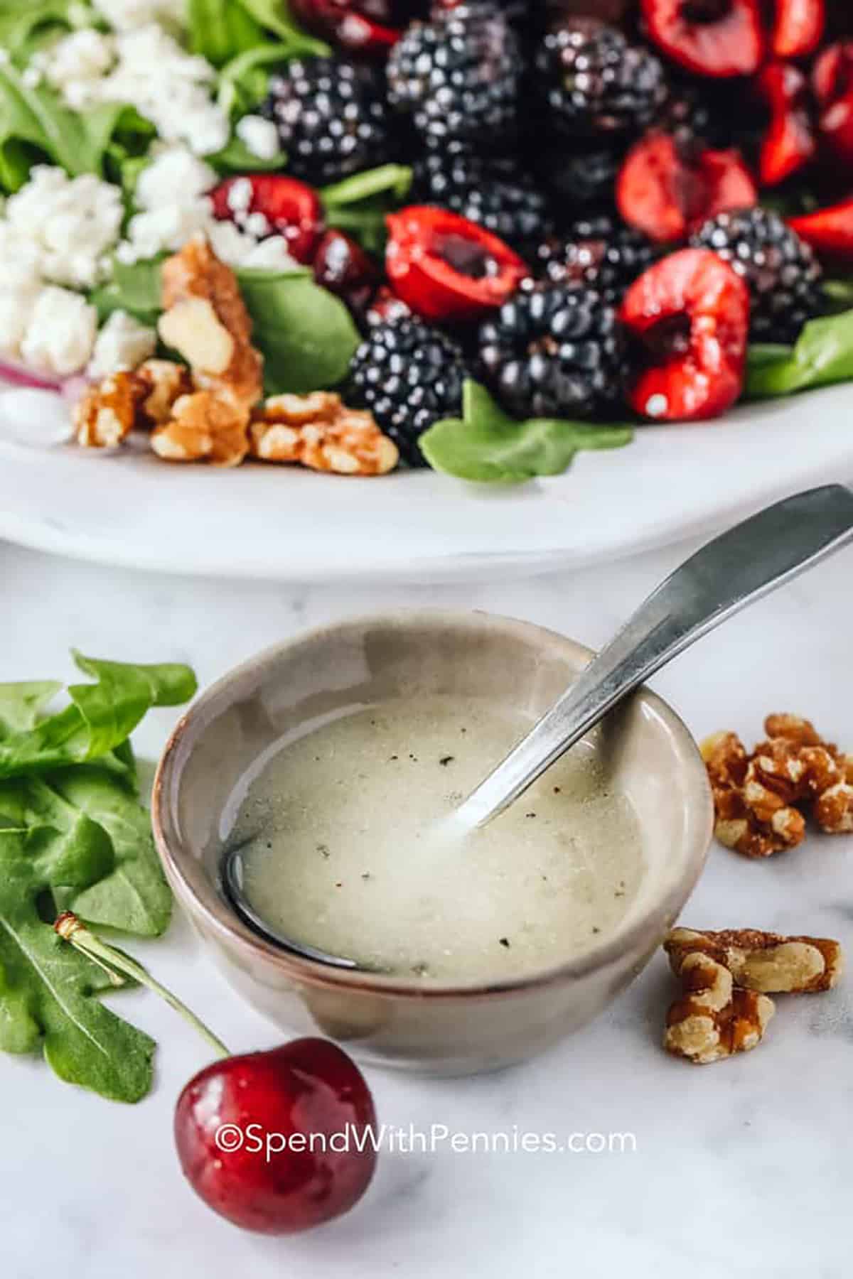 bowl of Easy Arugula Salad Dressing with plated salad