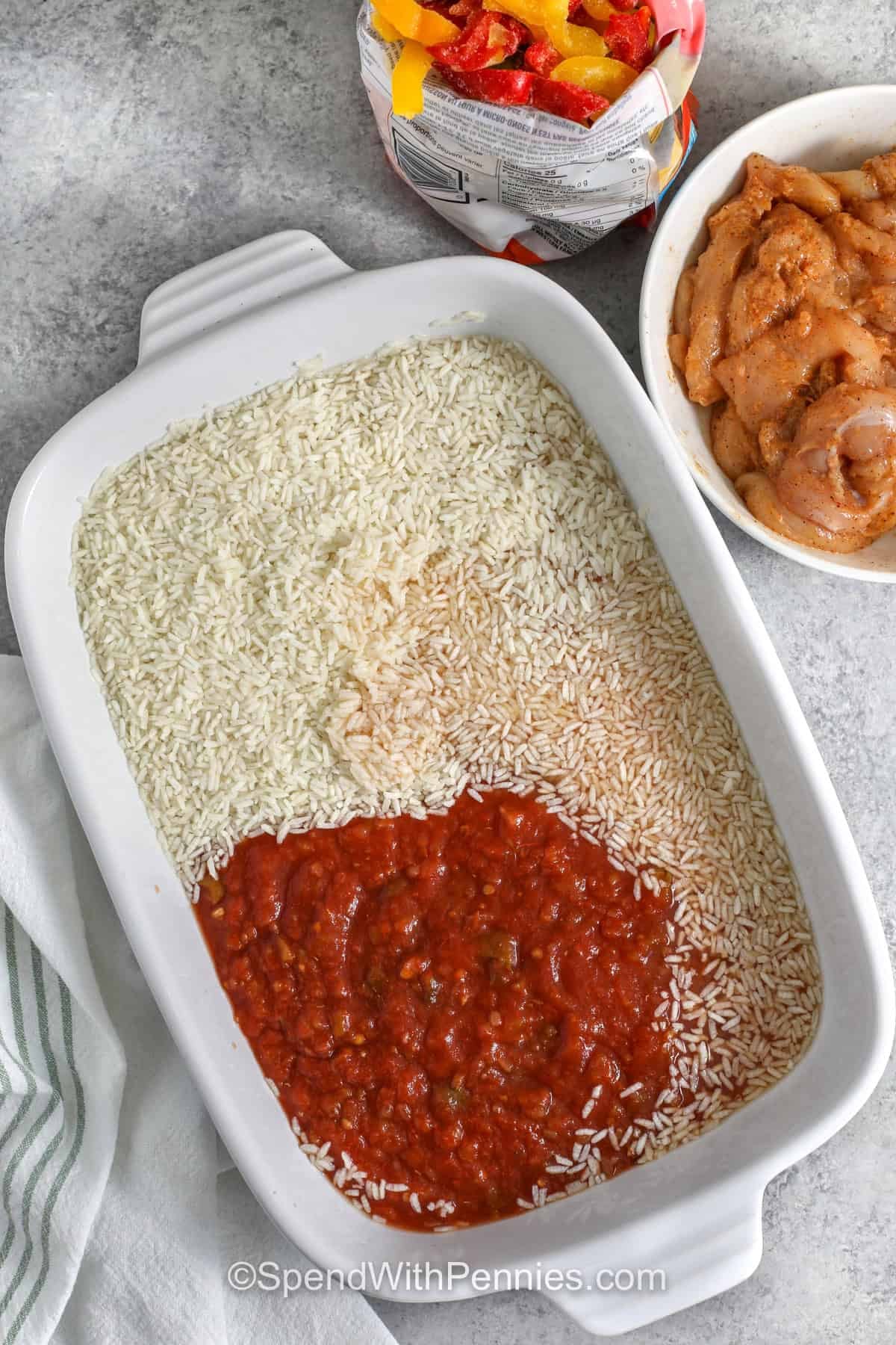 This chicken fajita casserole is the kind of recipe that makes dinner feel easy without tasting rushed. Long grain rice bakes with salsa and broth while chicken, peppers, and onions cook right on top, creating a full meal in one dish. Finish it with melted Mexican cheese blend and fresh toppings like avocado or sour cream for a cozy, colorful dinner everyone can build their own way. #spendwithpennies adding salsa to rice in casserole dish to make Chicken Fajita Casserole