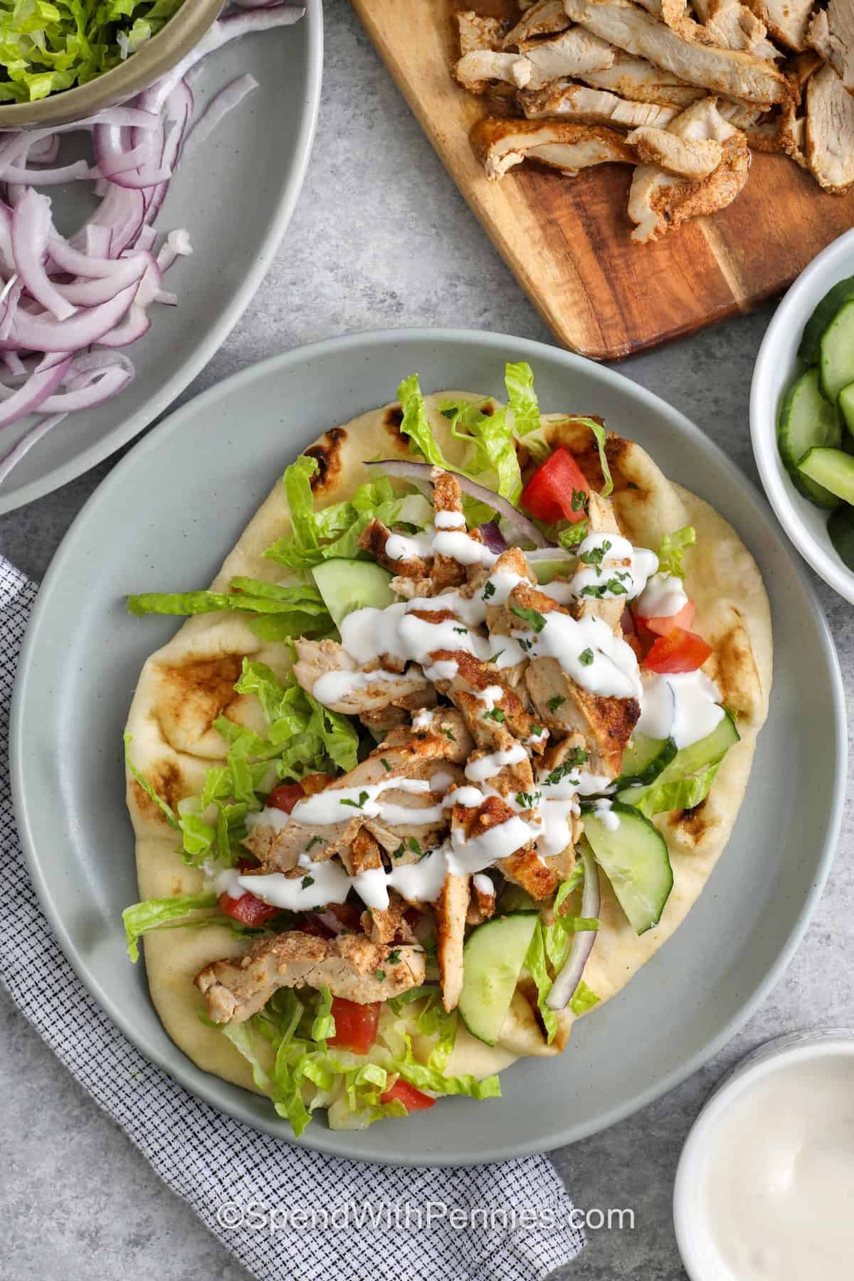 This oven chicken shawarma recipe gives you deeply seasoned chicken without needing a rotisserie or grill. Chicken thighs or cutlets are coated in yogurt, lemon, garlic, olive oil, and shawarma spices, then stacked in a loaf pan and baked until tender. Slice the chicken thin, drizzle it with the reserved juices, and serve it in wraps, bowls, or salads with crunchy toppings. #spendwithpennies plated Chicken Shawarma
