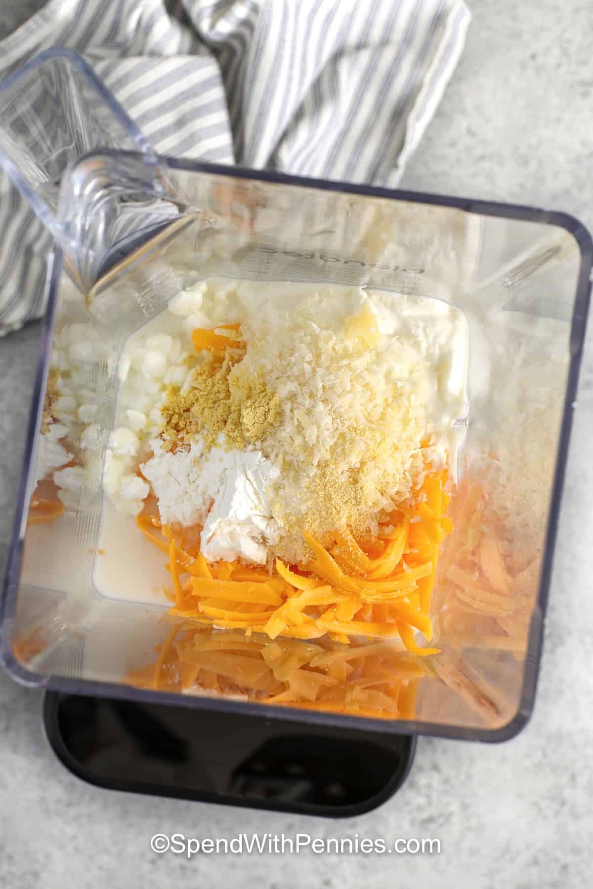 adding ingredients to blender to make Cottage Cheese Mac and Cheese