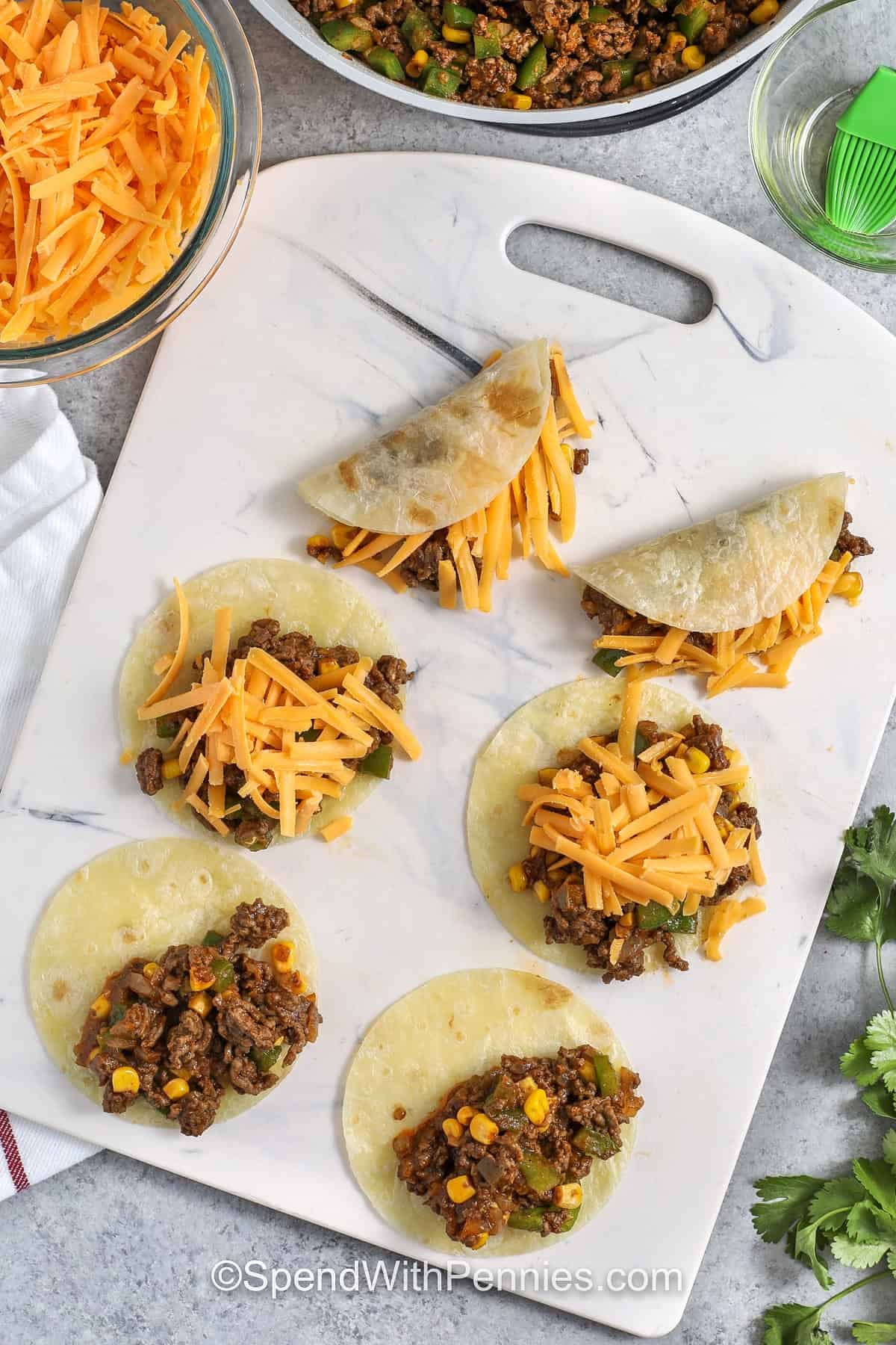 crispy tacos on a cutting board uncooked