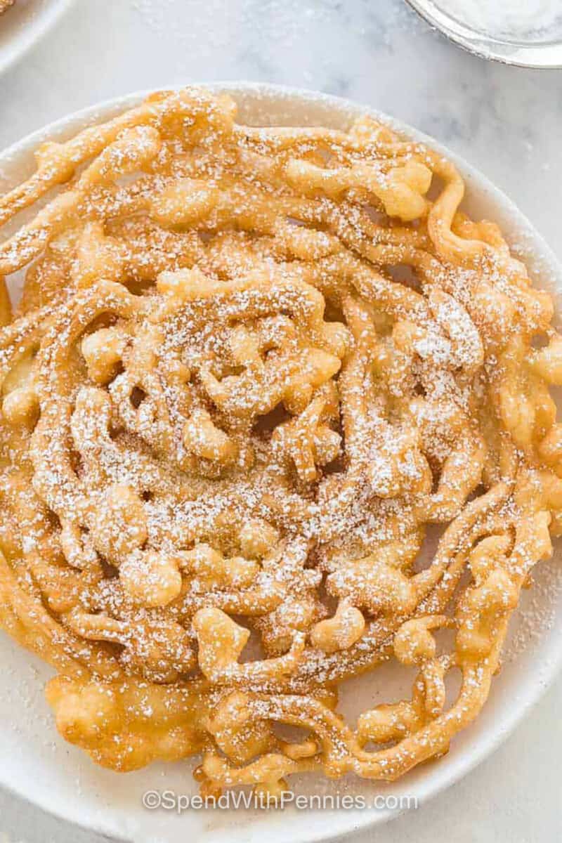 Homemade Funnel Cake on a plate with powdered sugar