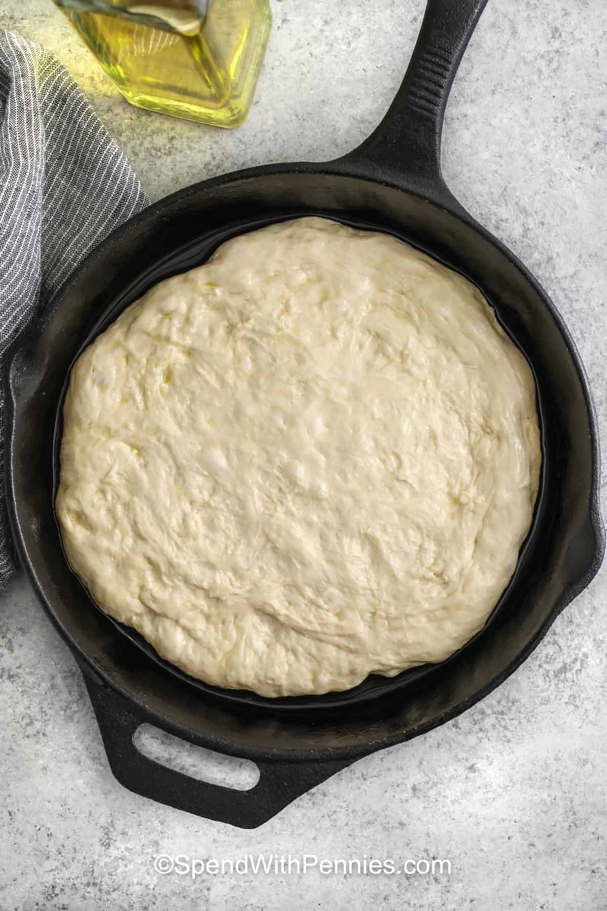 This homemade cast iron skillet pan pizza has the kind of crisp, golden crust that makes every slice feel bakery-style and special. It uses a handful of familiar ingredients like pizza dough, olive oil, pizza sauce, mozzarella, pepperoni, and Parmesan, so it is easy to pull together. Serve it with salad or soup for a cozy meal, and reheat leftovers in a skillet for that same crisp texture the next day. #spendwithpennies adding pizza dough to pan to make Homemade Pan Pizza