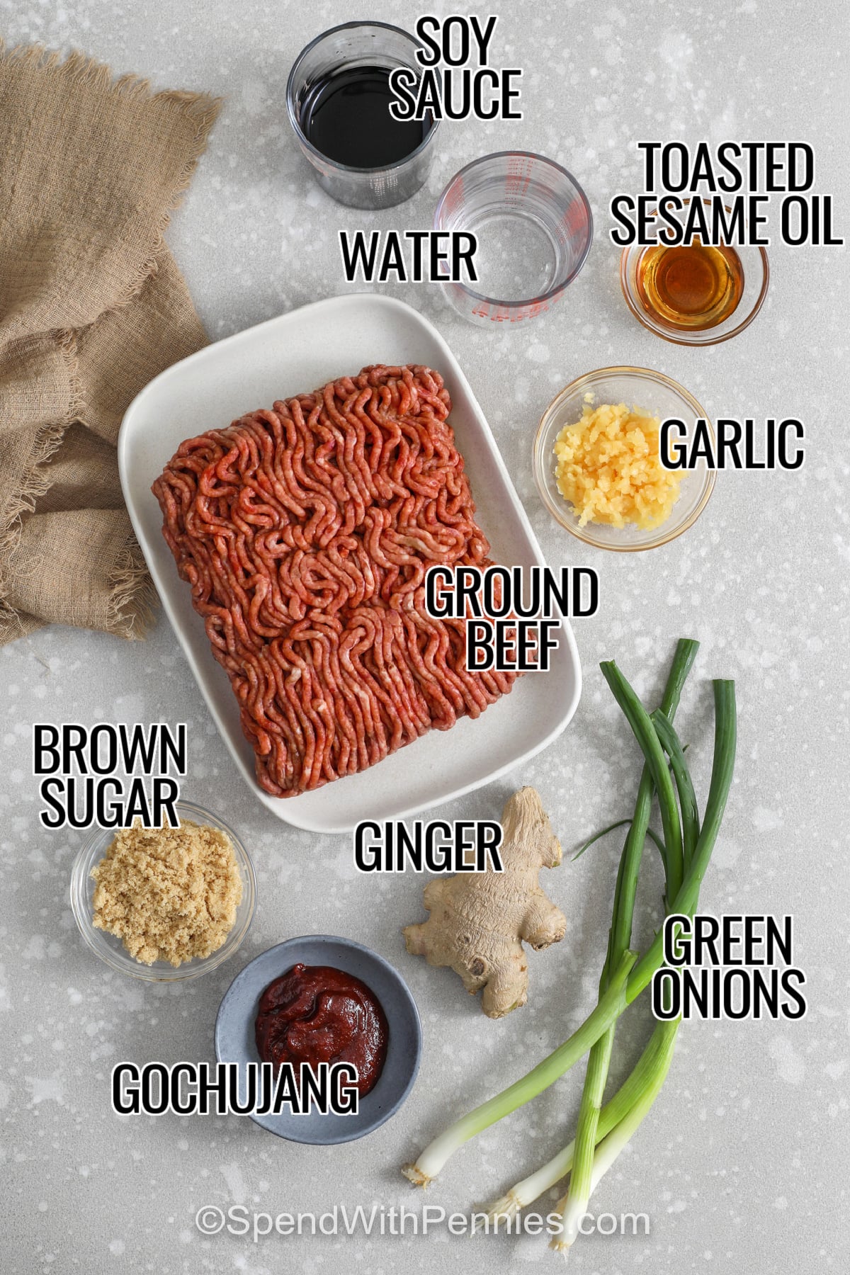 Ingredients to make a Korean Beef Bowl labeled: soy sauce, toasted sesame oil, ginger, ground beef, brown sugar, gochujang, and green onions