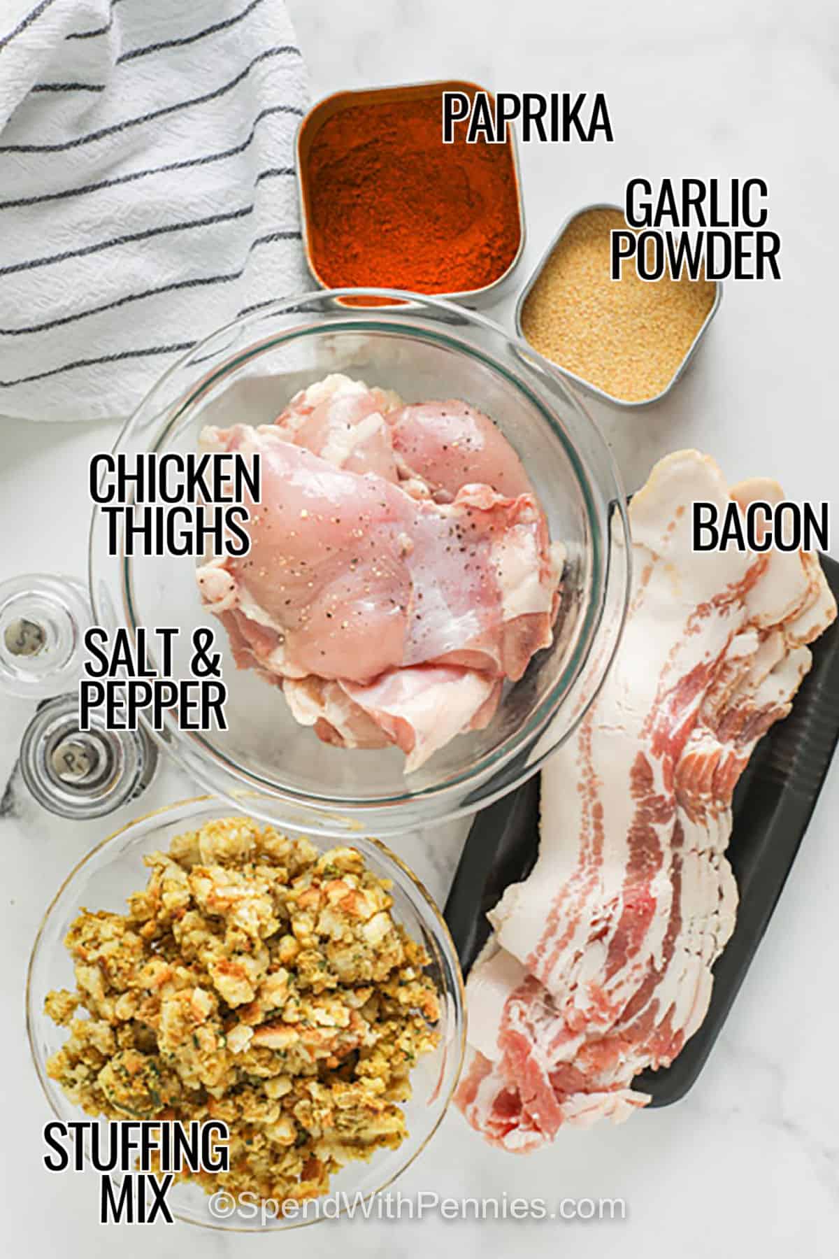 Stuffed chicken thighs are a cozy dinner idea that turns simple ingredients into something that feels special. Boneless chicken thighs are filled with savory stuffing, wrapped in bacon, and baked until juicy inside with crisp edges outside. This recipe is especially handy when you have leftover stuffing to use up, but boxed stuffing mix works just as well for an easy weeknight dinner with plenty of comfort food appeal. #spendwithpennies paprika , garlic powder , bacon , chicken thighs , stuffing mix , salt and pepper with labels to make Stuffed Chicken Thighs