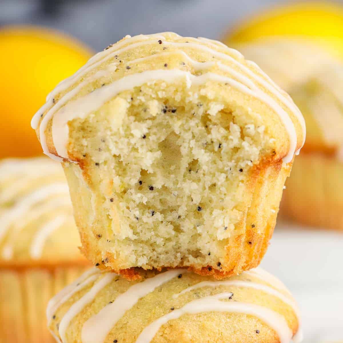 stack of Lemon Poppy Seed Muffins with a bite taken out of one