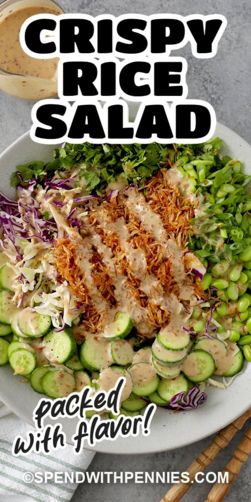 A large bowl with chopped cilantro, green onions, edamame, sliced cucumbers, coleslaw mix, crispy rice, and sesame dressing with text.