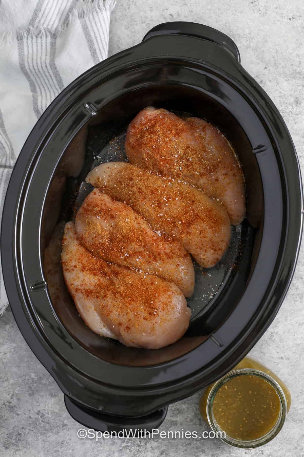 adding seasoning to chicken to make Salsa Verde Chicken