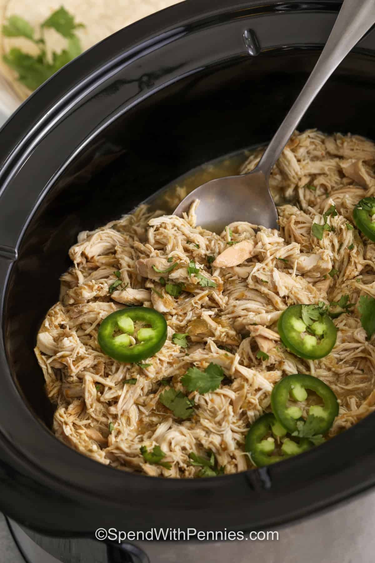 taking a spoonful of Salsa Verde Chickenout of the crockpot