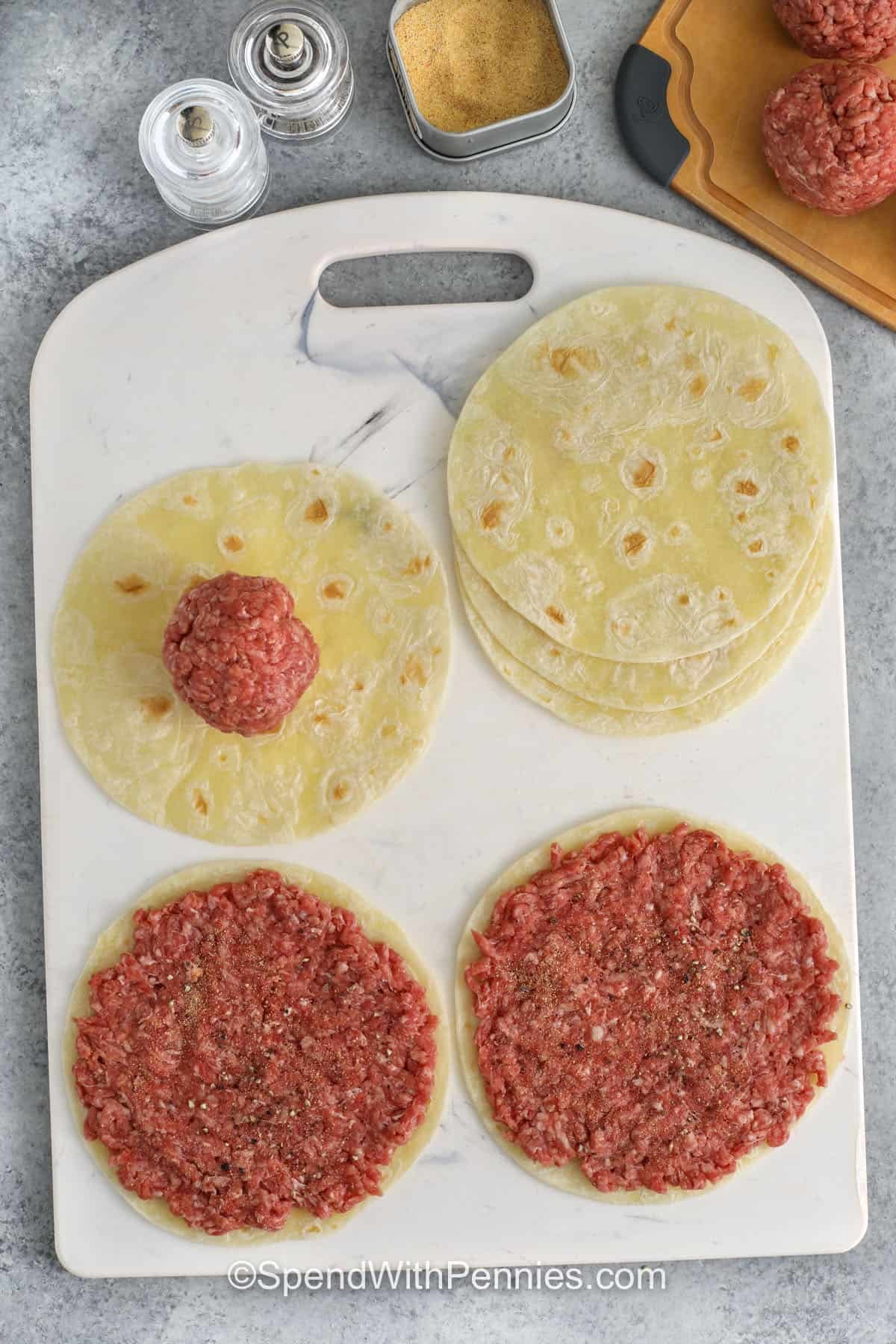 adding ground beef to tortillas to make Smash Burger Tacos