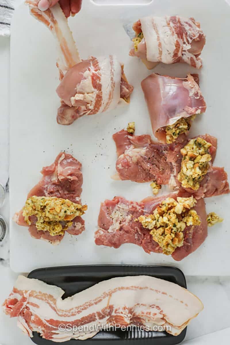 Bacon wrapped stuffed chicken thighs are perfect for home cooks who want a dinner that is practical, flavorful, and family friendly. The thighs are easy to fold around prepared stuffing, and the bacon adds both flavor and moisture as everything bakes in the oven. This recipe works well for meal prep, cooler weather dinners, or when you want to turn leftover stuffing into a brand-new main dish. #spendwithpennies adding stuffing and bacon to chicken thighs to make Stuffed Chicken Thighs