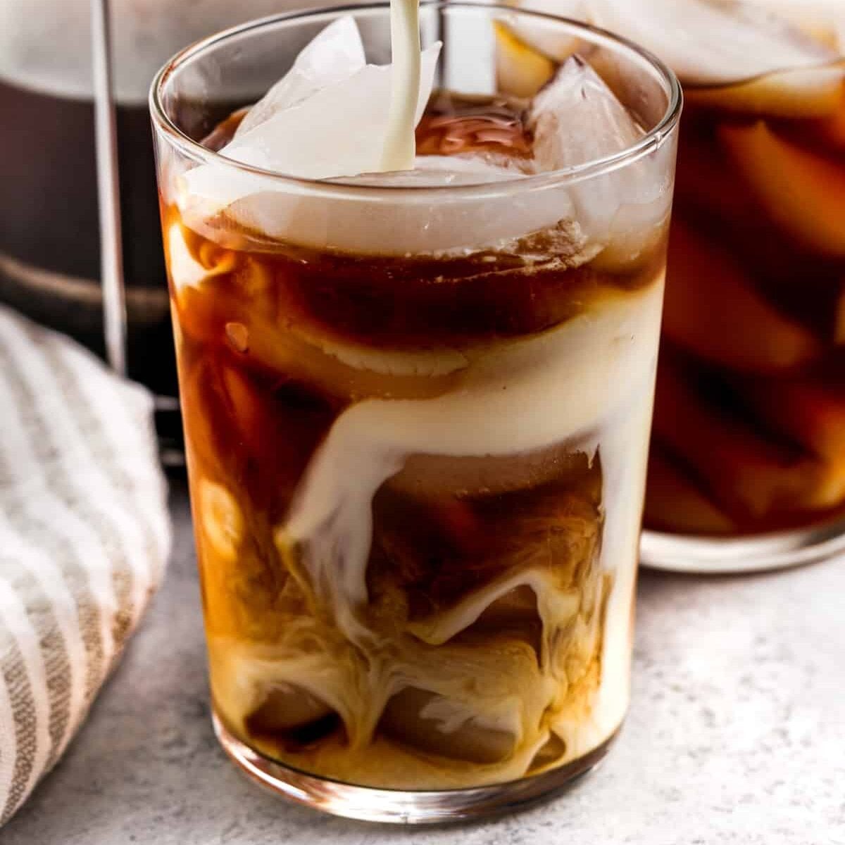 adding cream to coffee to make Vanilla Sweet Cream Cold Brew