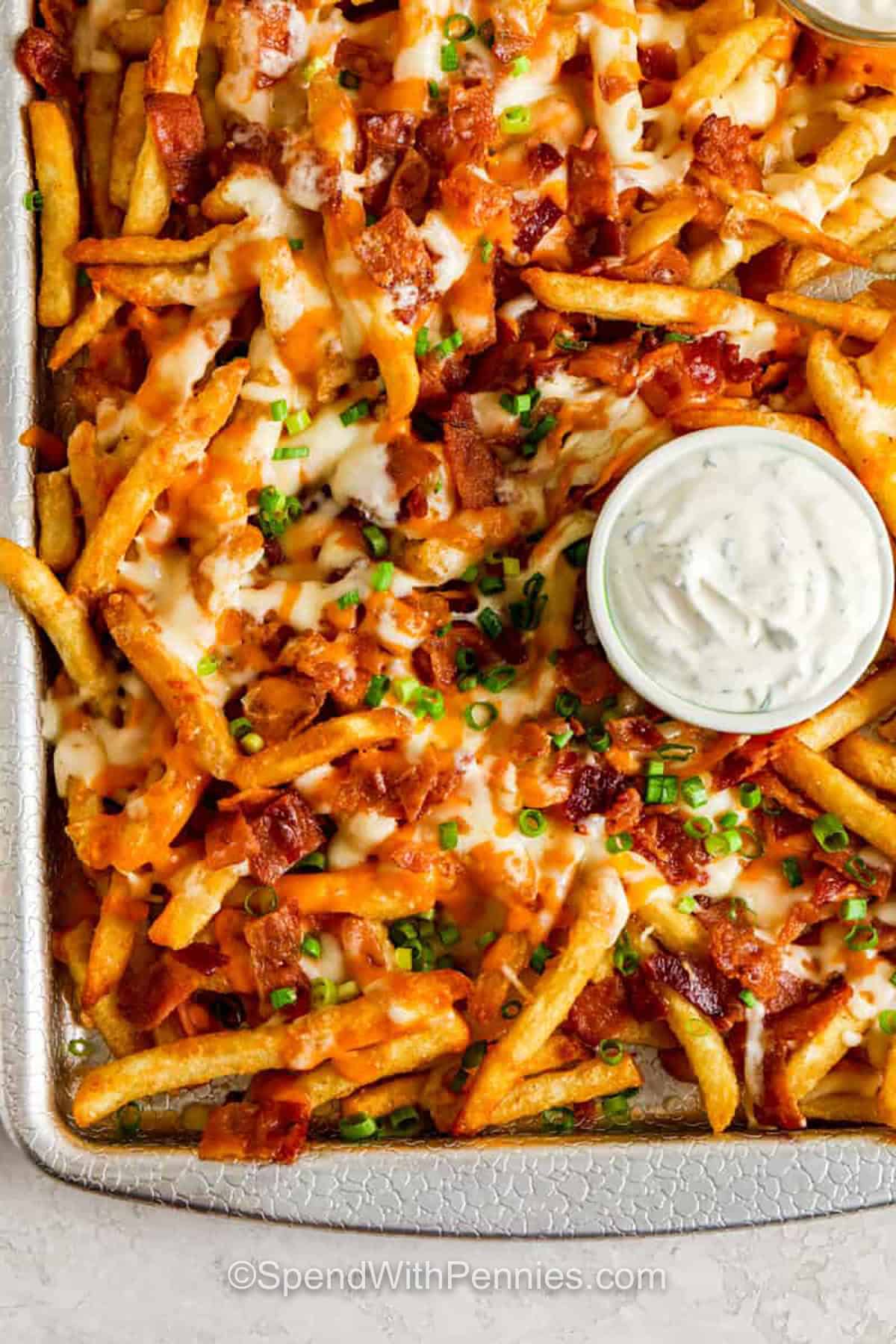 sheet pan of Loaded Cheese Fries with dip