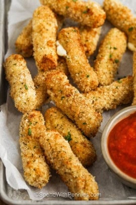 sheet pan of crispy Air Fryer Mozzarella Sticks with marinara