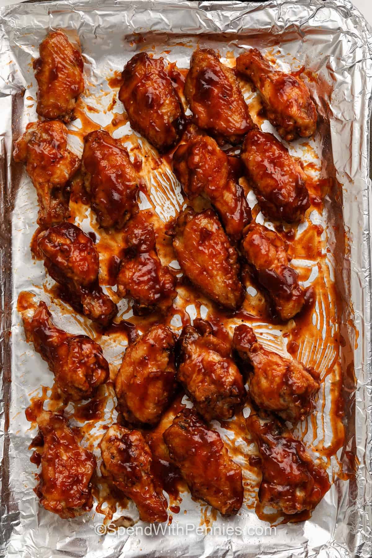 adding sauce to chicken wings to make BBQ Chicken Wings
