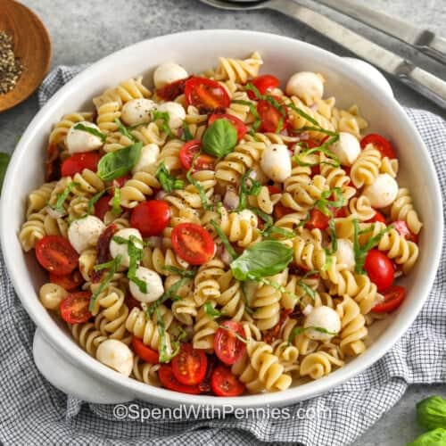 bowl of Caprese Pasta Salad with balsamic glaze and pepper