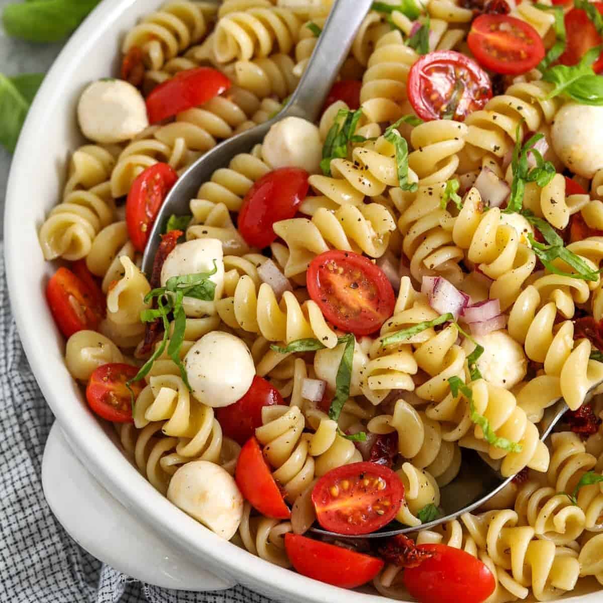 Caprese Pasta Salad in a bowl with spoons