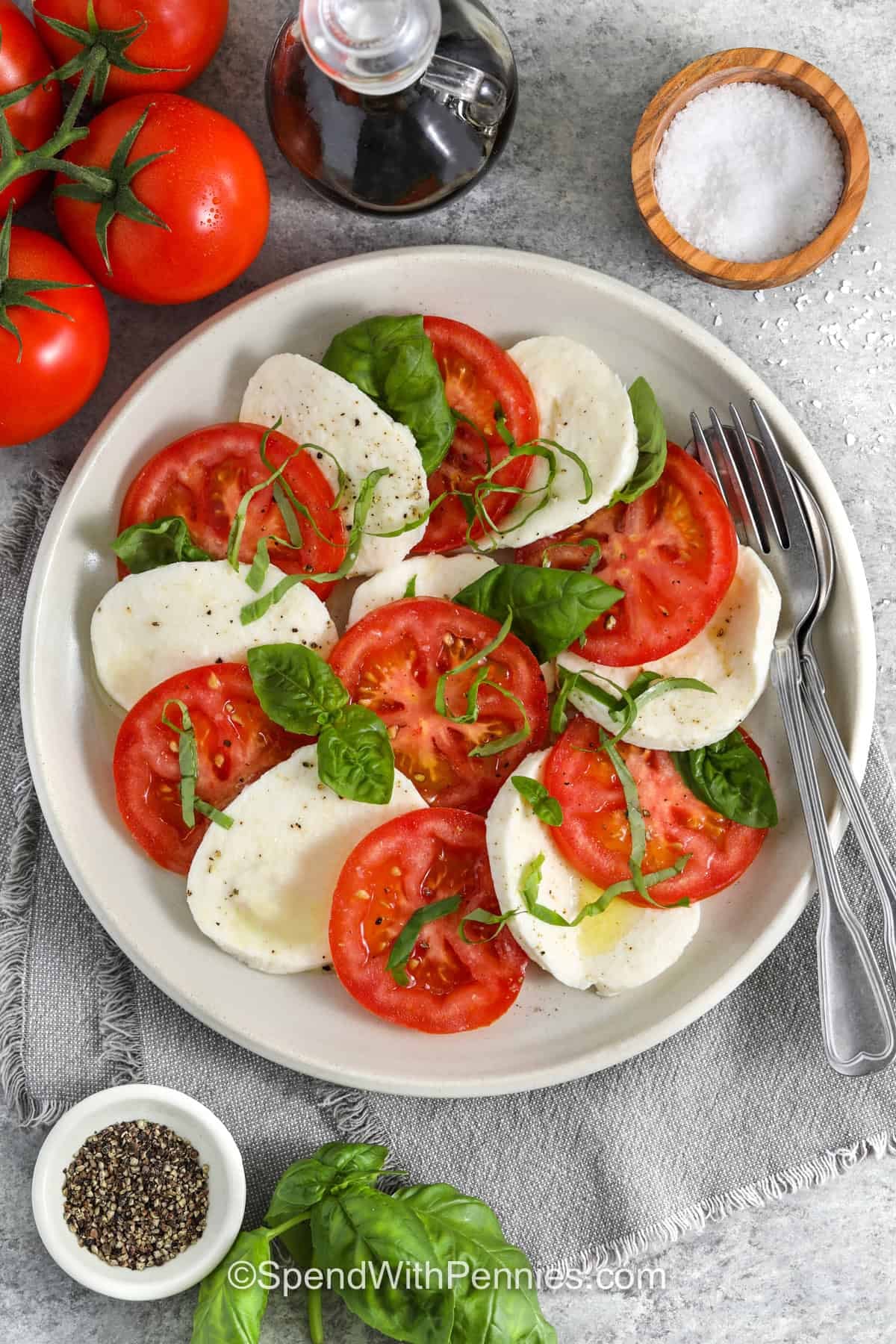 plate of Caprese Salad with a fork and spoon