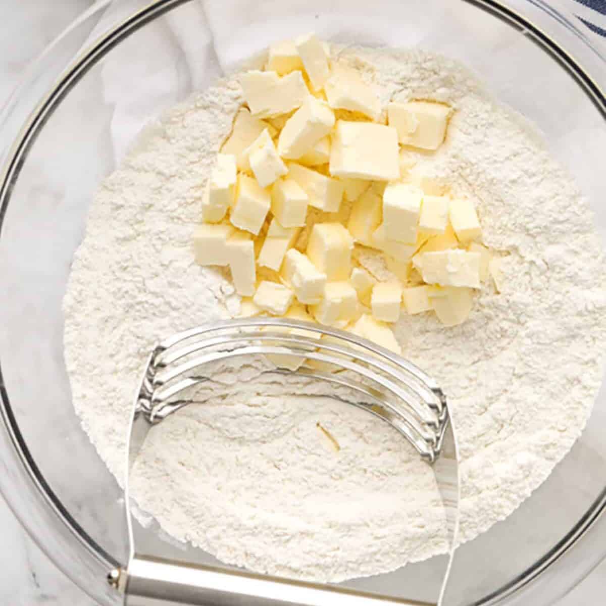 cutting butter into flour to make Homemade Biscuits