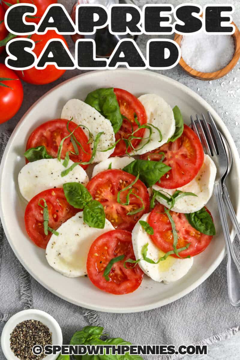 This fresh mozzarella tomato basil Caprese salad is a classic summer recipe with juicy tomatoes, creamy cheese, and fragrant basil in every bite. A little olive oil and balsamic vinegar bring everything together without hiding the fresh ingredients. Make this Italian-inspired Caprese salad for cookouts, picnics, potlucks, or easy dinners when you want something colorful, simple, and full of garden-fresh flavor. #spendwithpennies caprese salad on a plate with a fork and writing