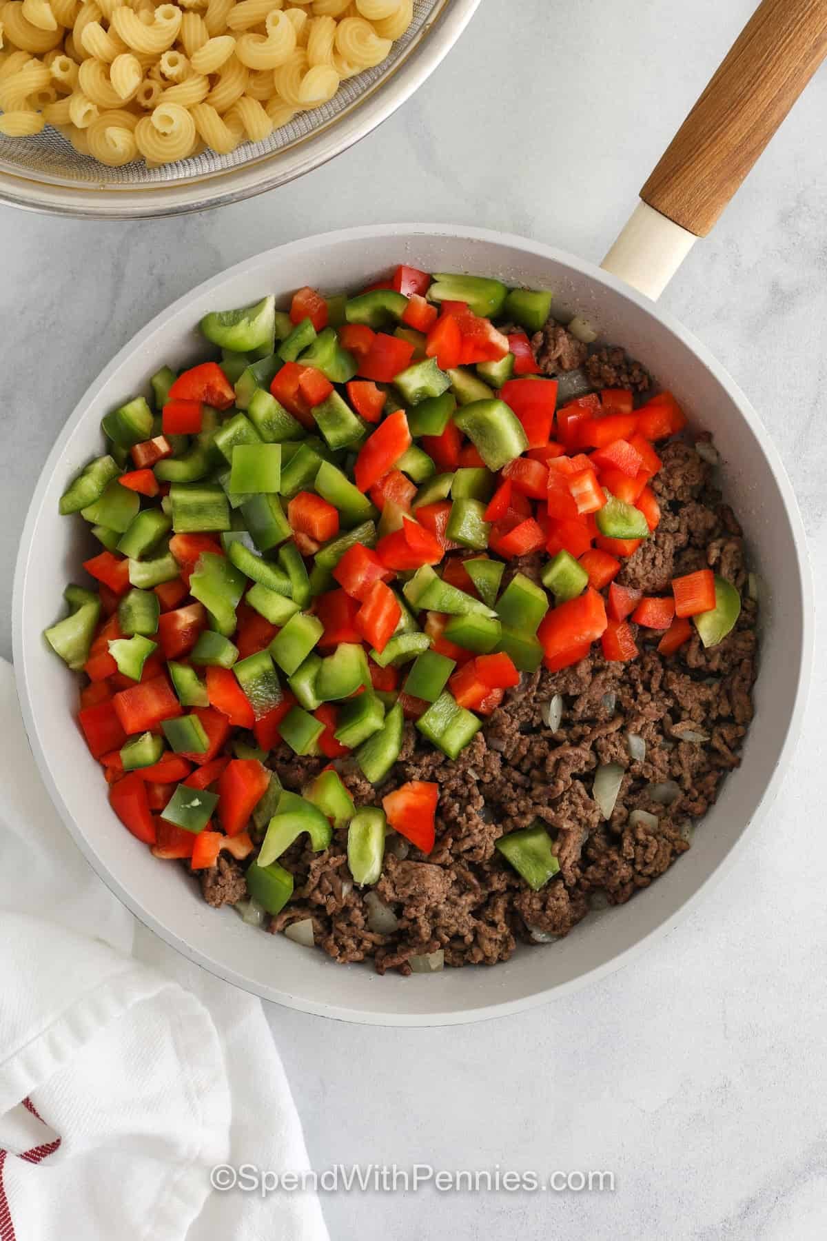 adding peppers to ground beef to make Sloppy Joe Casserole