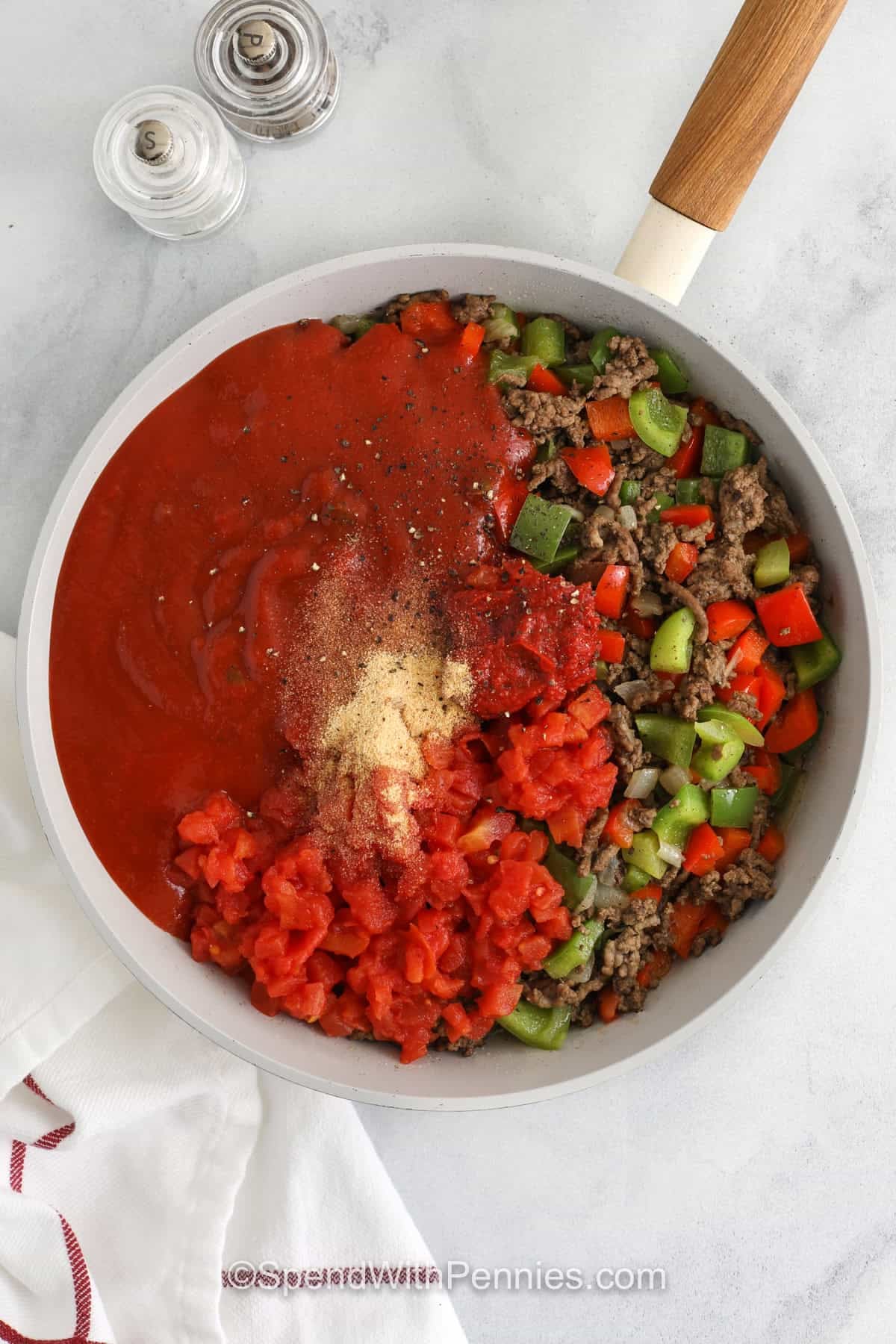 adding tomato paste , sloppy Joe sauce, tomatoes and seasonings to beef and peppers to make Sloppy Joe Casserole