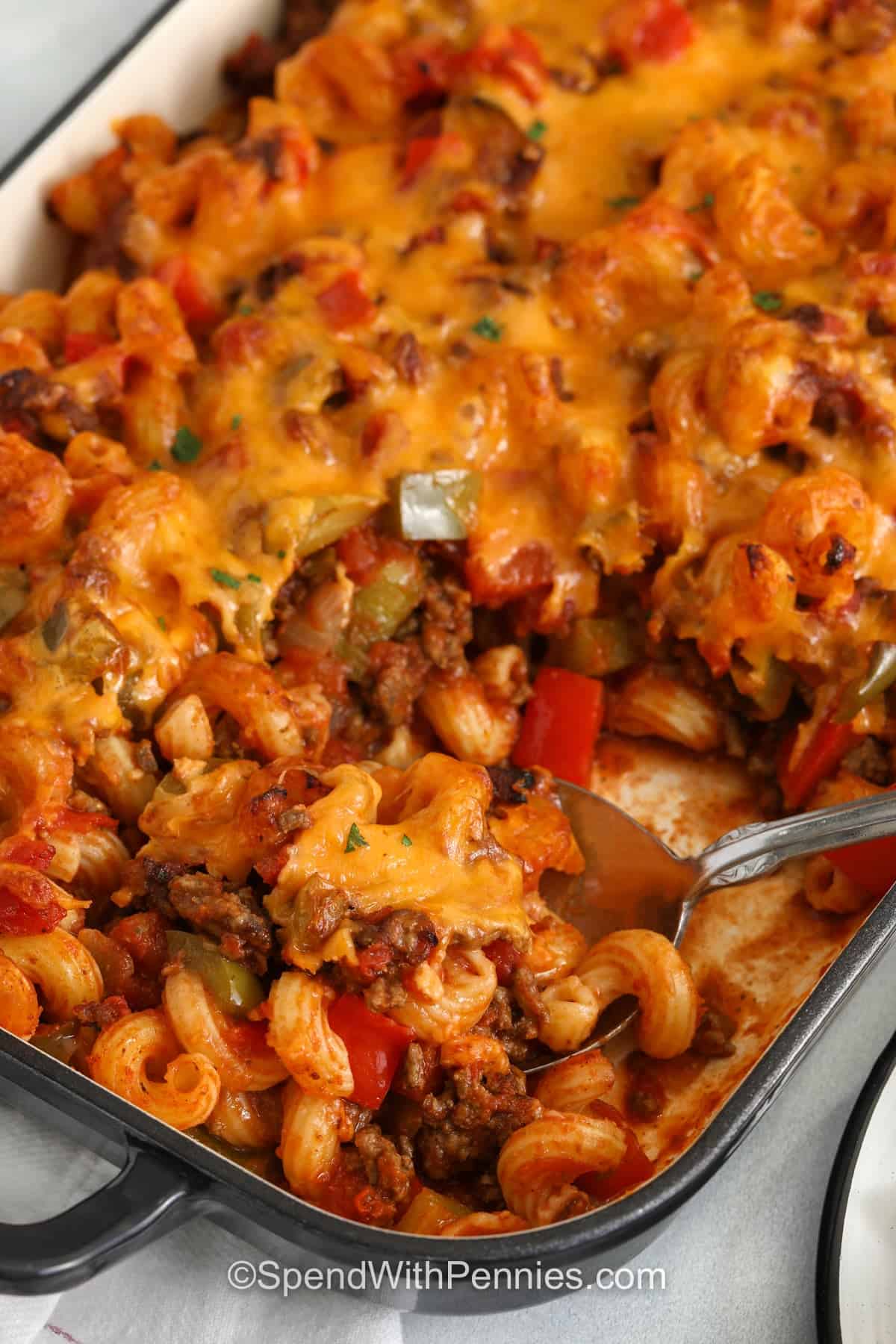 taking a spoonful of Sloppy Joe Casserole out of the dish
