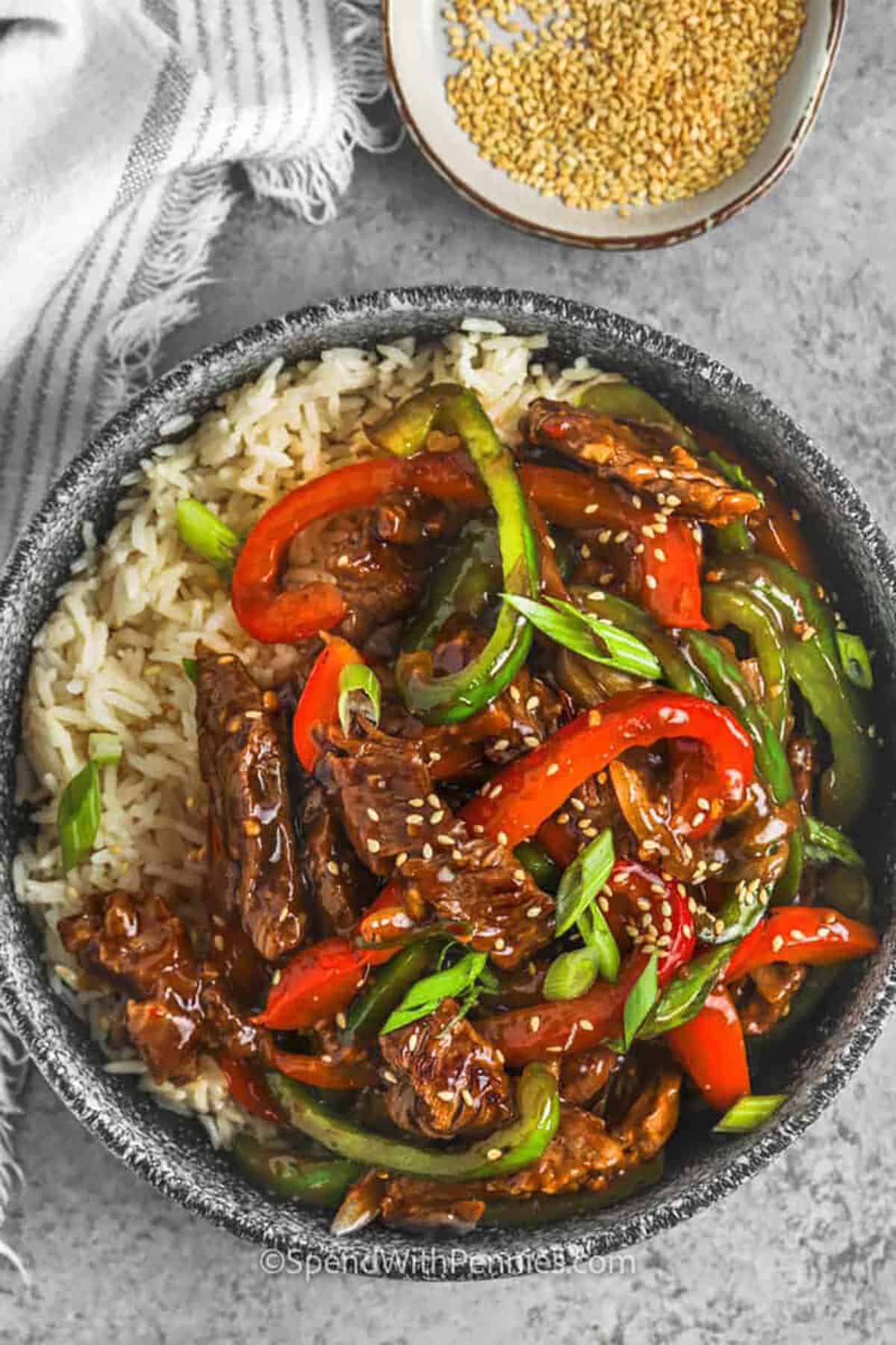 This pepper steak recipe is made with thin strips of beef, sweet bell peppers, and onions cooked in a glossy soy-based sauce. The beef marinates with garlic, ginger, honey, and Worcestershire for extra flavor before it is quickly seared in a hot skillet. Serve it over rice or noodles for a comforting takeout-style dinner that feels special but uses simple ingredients. #spendwithpennies Pepper Steak stir fry in a bowl