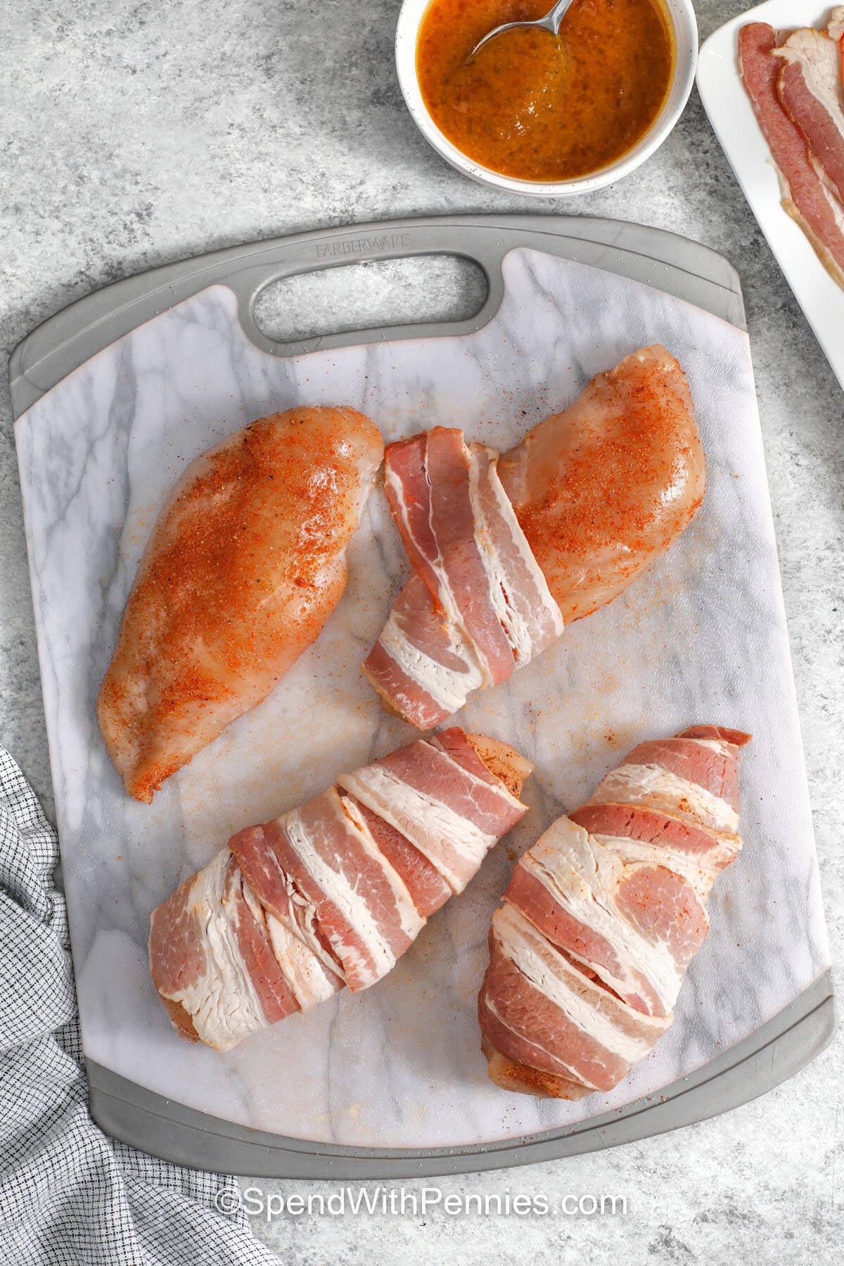 wrapping chicken in bacon to make Bacon Wrapped Chicken