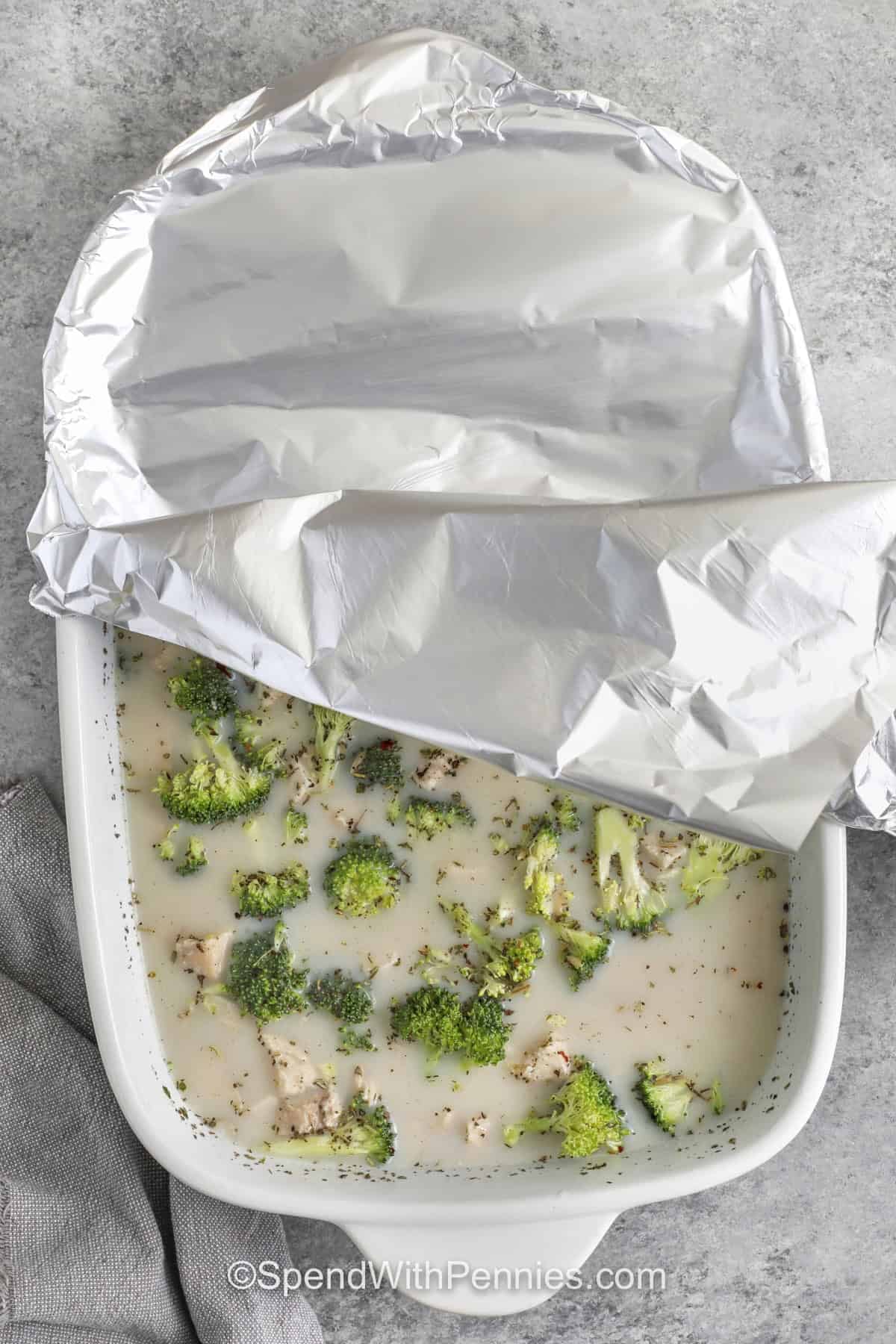 This baked chicken and orzo recipe has tender pasta, juicy chicken, broccoli, and a creamy cheddar Parmesan finish. It is a no boil casserole that starts with dry orzo and ends with a cozy, family style dinner. Leftovers reheat well with a splash of milk or broth, making this chicken orzo bake a practical recipe for meal prep and next day lunches. #spendwithpennies adding tin foil on top of dish to make Chicken Orzo Bake