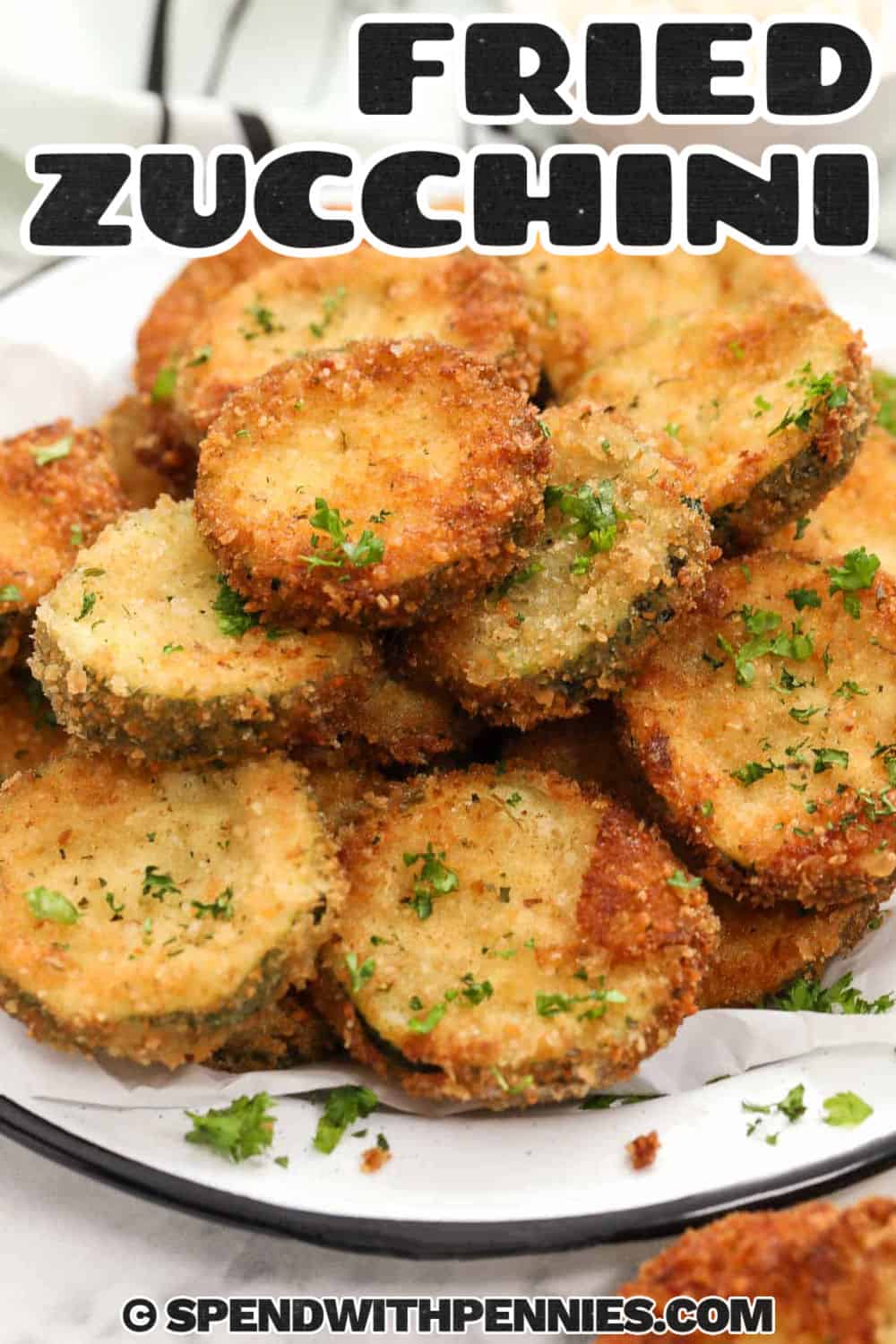 Make fried zucchini medallions with simple ingredients like zucchini, eggs, flour, parmesan cheese, and seasoned breadcrumbs. Each slice cooks quickly in hot oil, giving you a crisp coating and tender center without a long prep time. This recipe is perfect for summer zucchini, family dinners, game day snacks, or a warm appetizer served with your favorite dip. Pin this zucchini recipe for your next pasta night. #spendwithpennies plated Fried Zucchini Recipe with a title